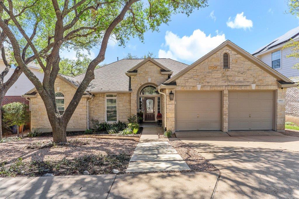 Mature shade trees frame this stone exterior home