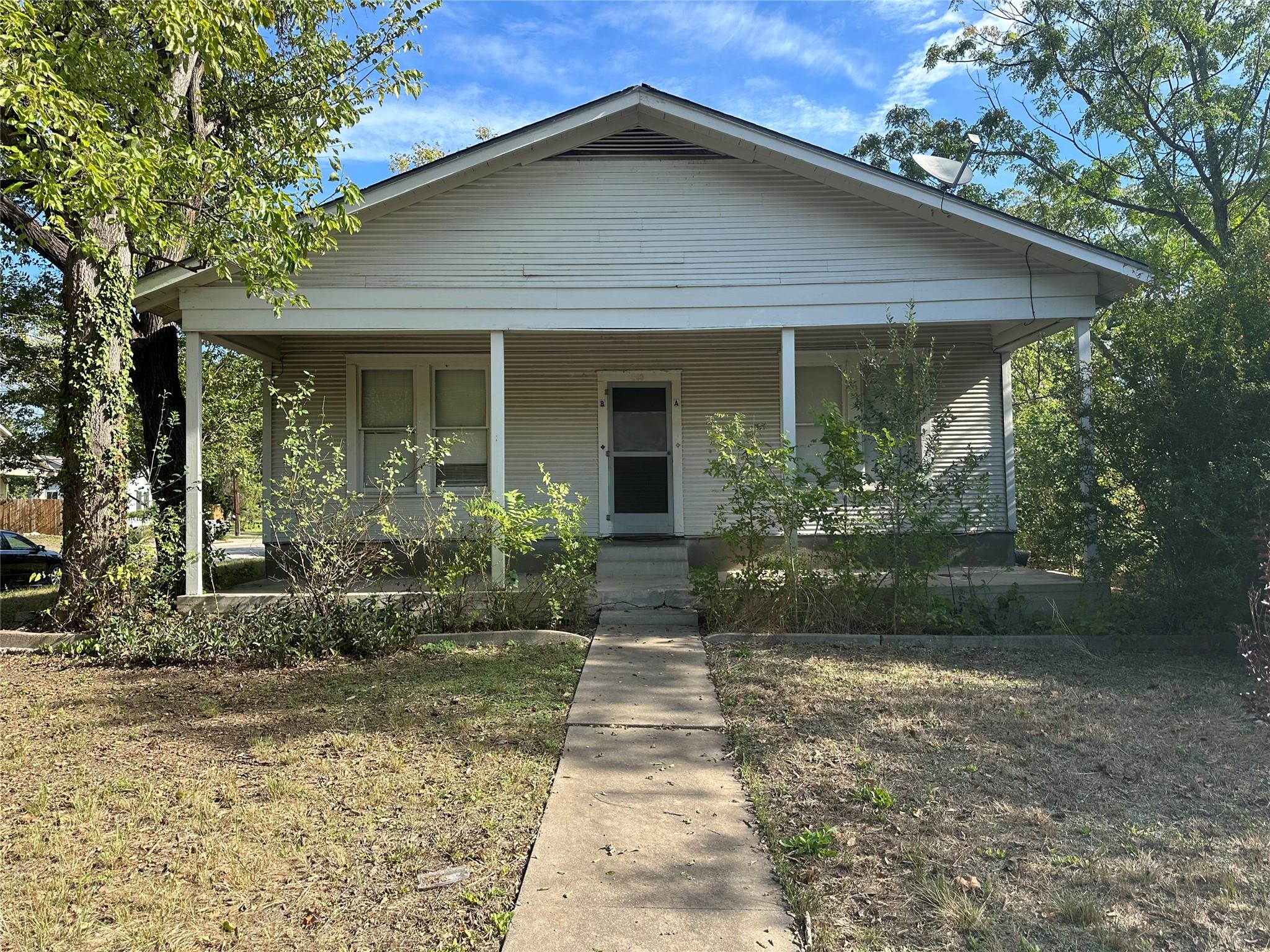 A concrete walkway leads to the welcoming covered