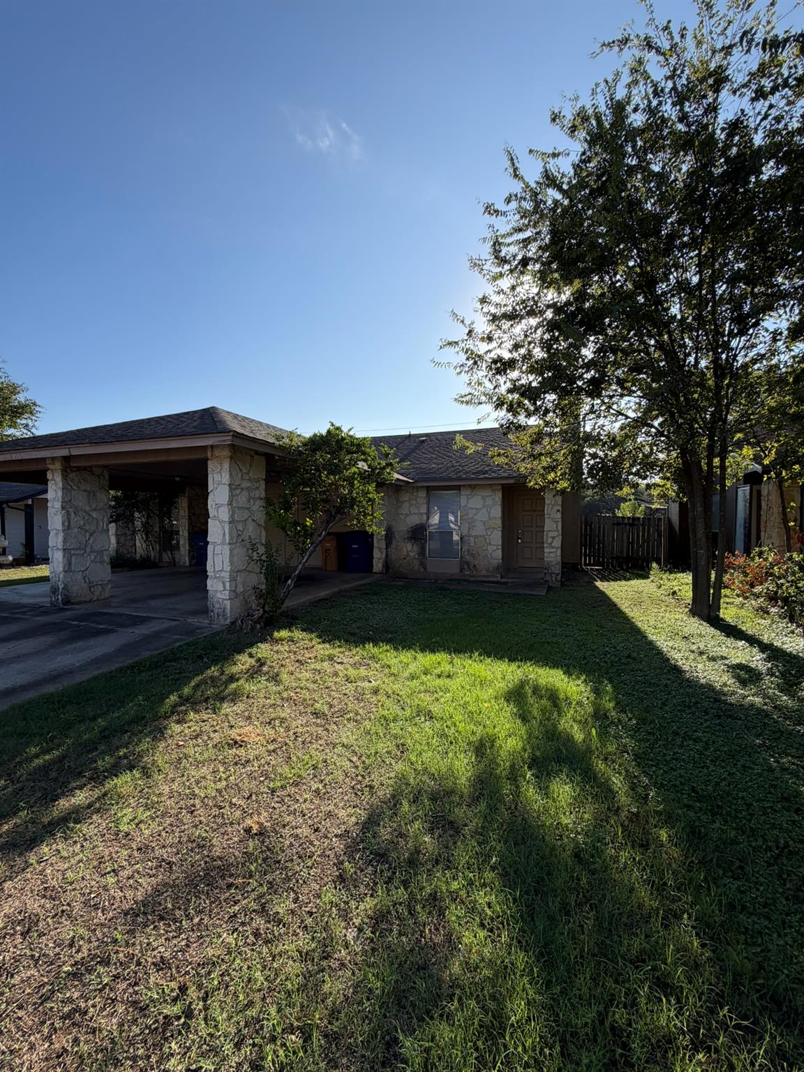 Natural stone accents and an attached carport def