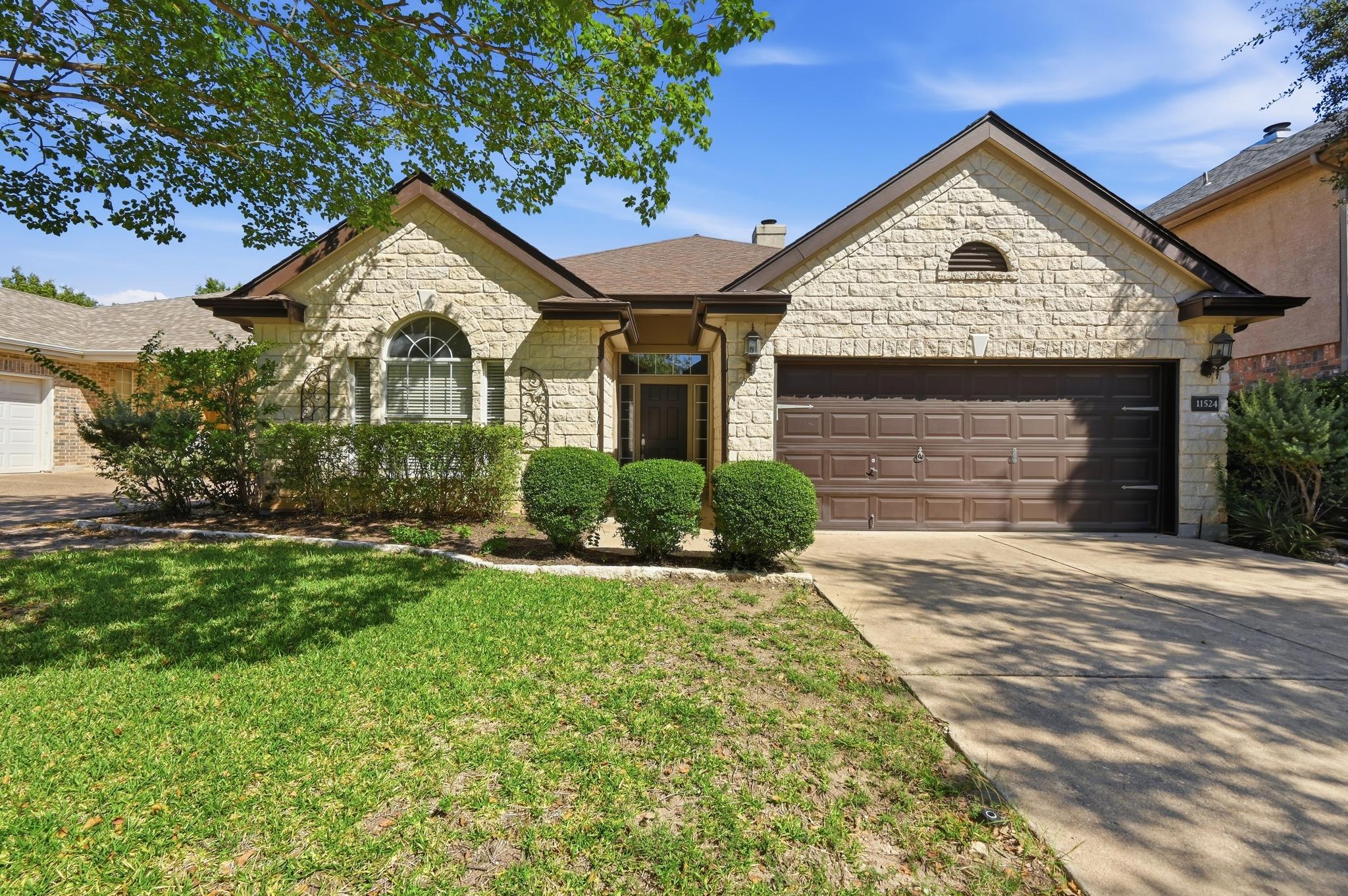 A classical stone facade and manicured lawn creat