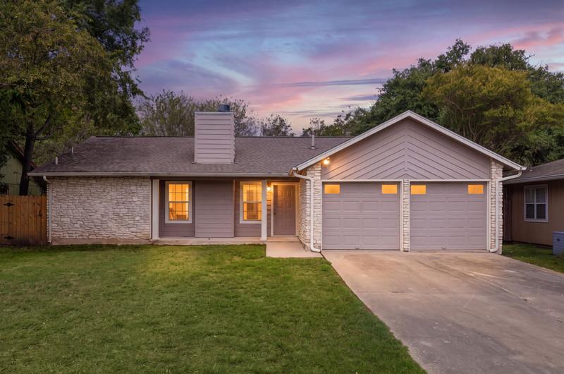 Textured stone accents and a spacious concrete dr