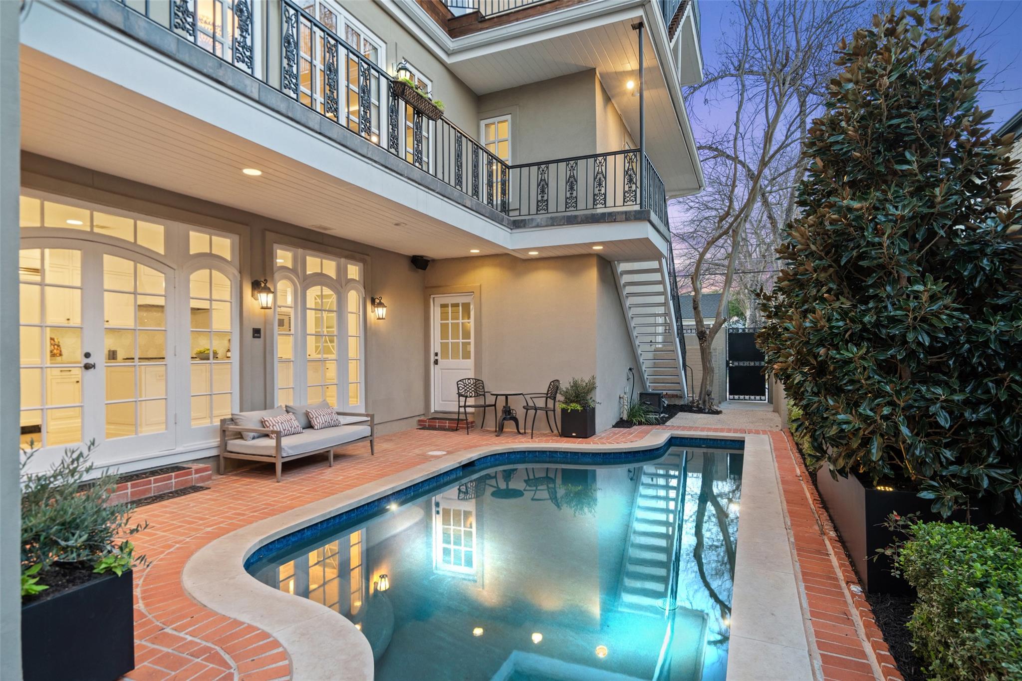 An inviting brick patio surrounds the custom swim