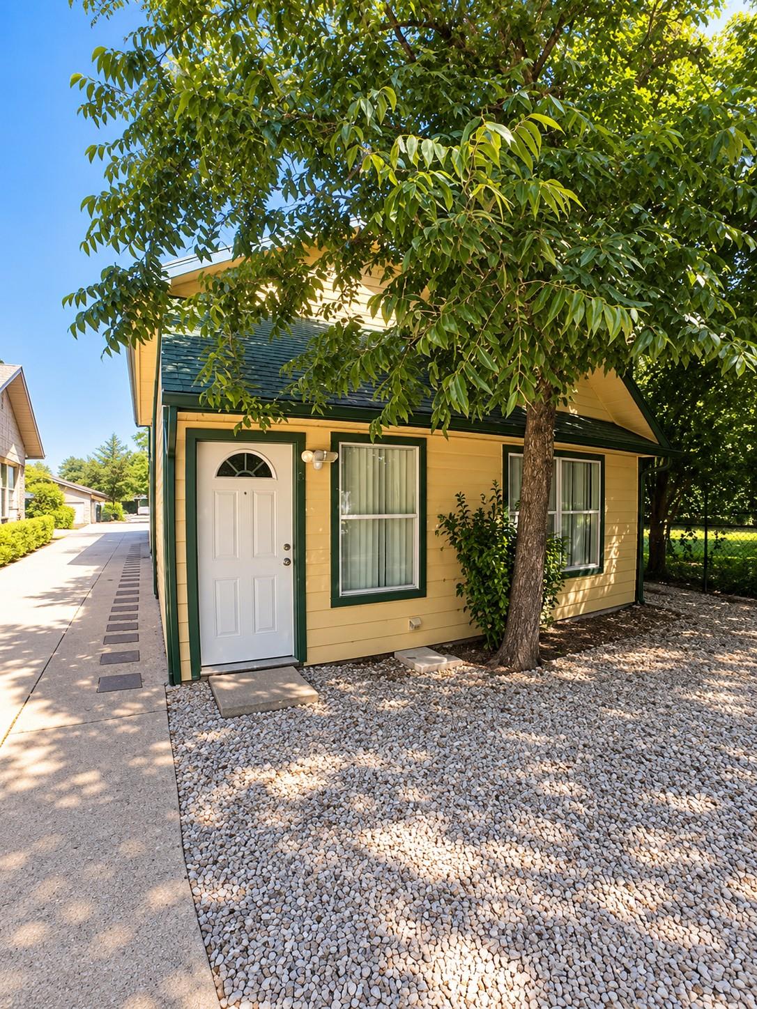 Mature trees shade a welcoming paved pathway lead