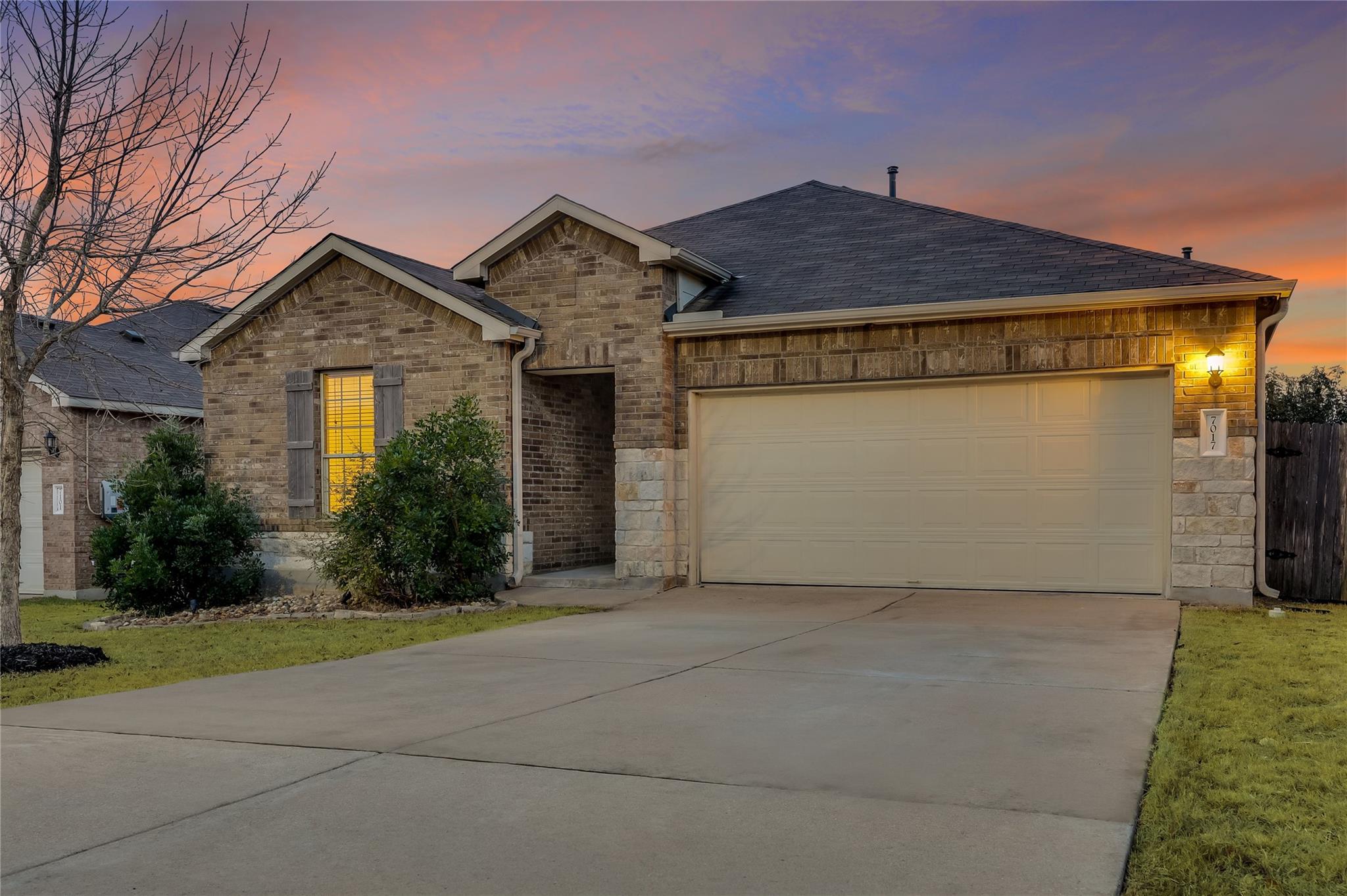 An inviting stone and brick exterior features a s