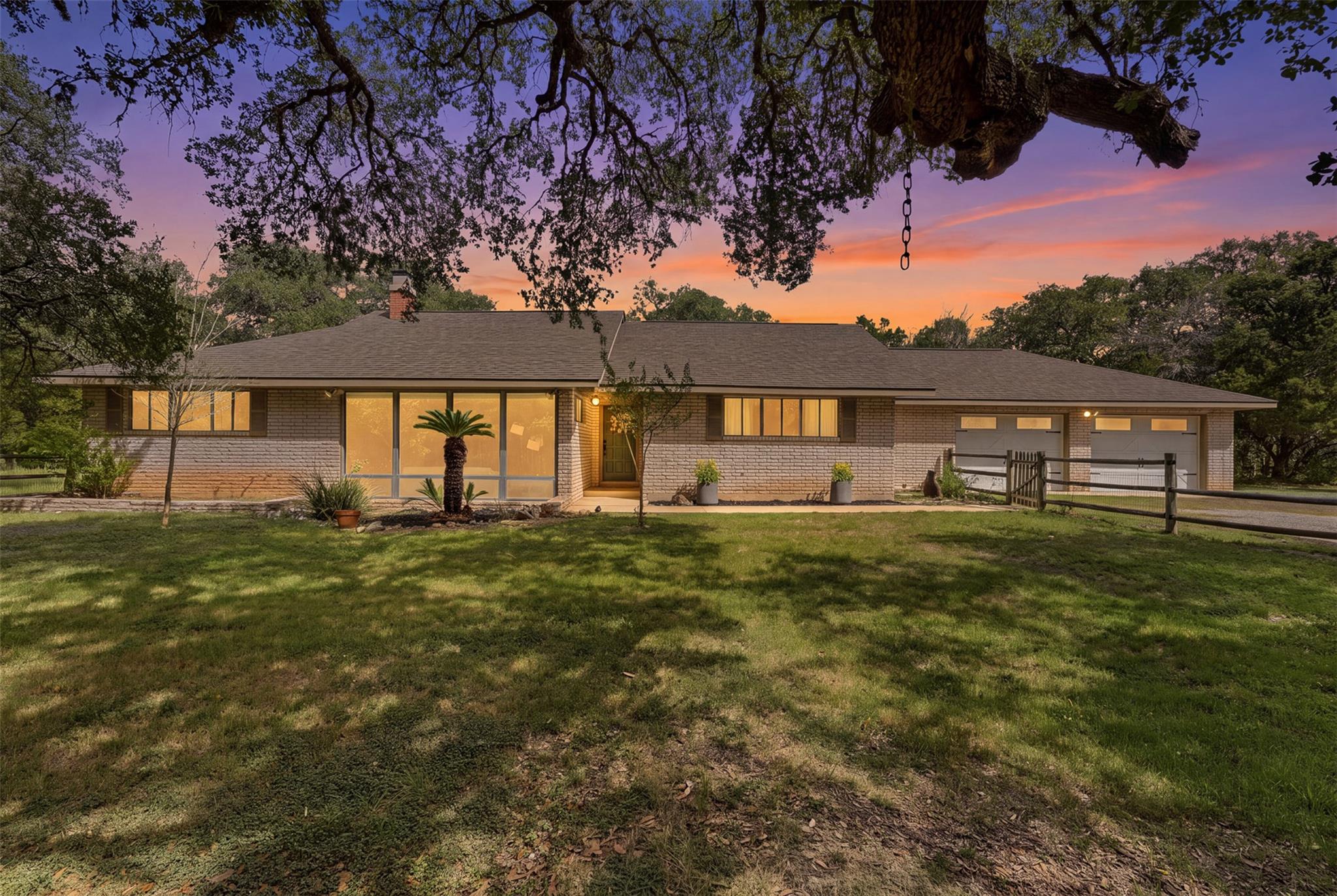 Mature trees frame the classic brick exterior of 