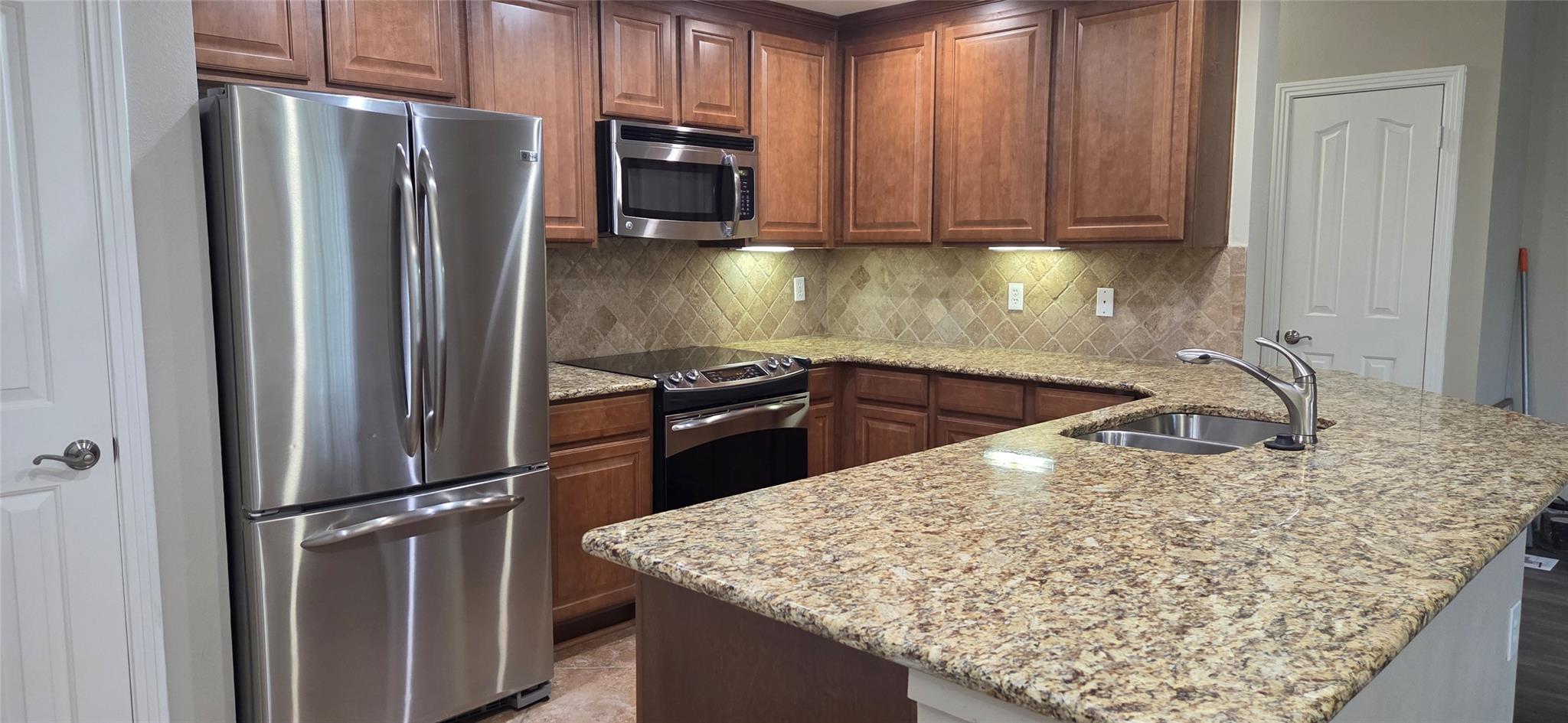 Rich wood cabinetry and polished granite countert