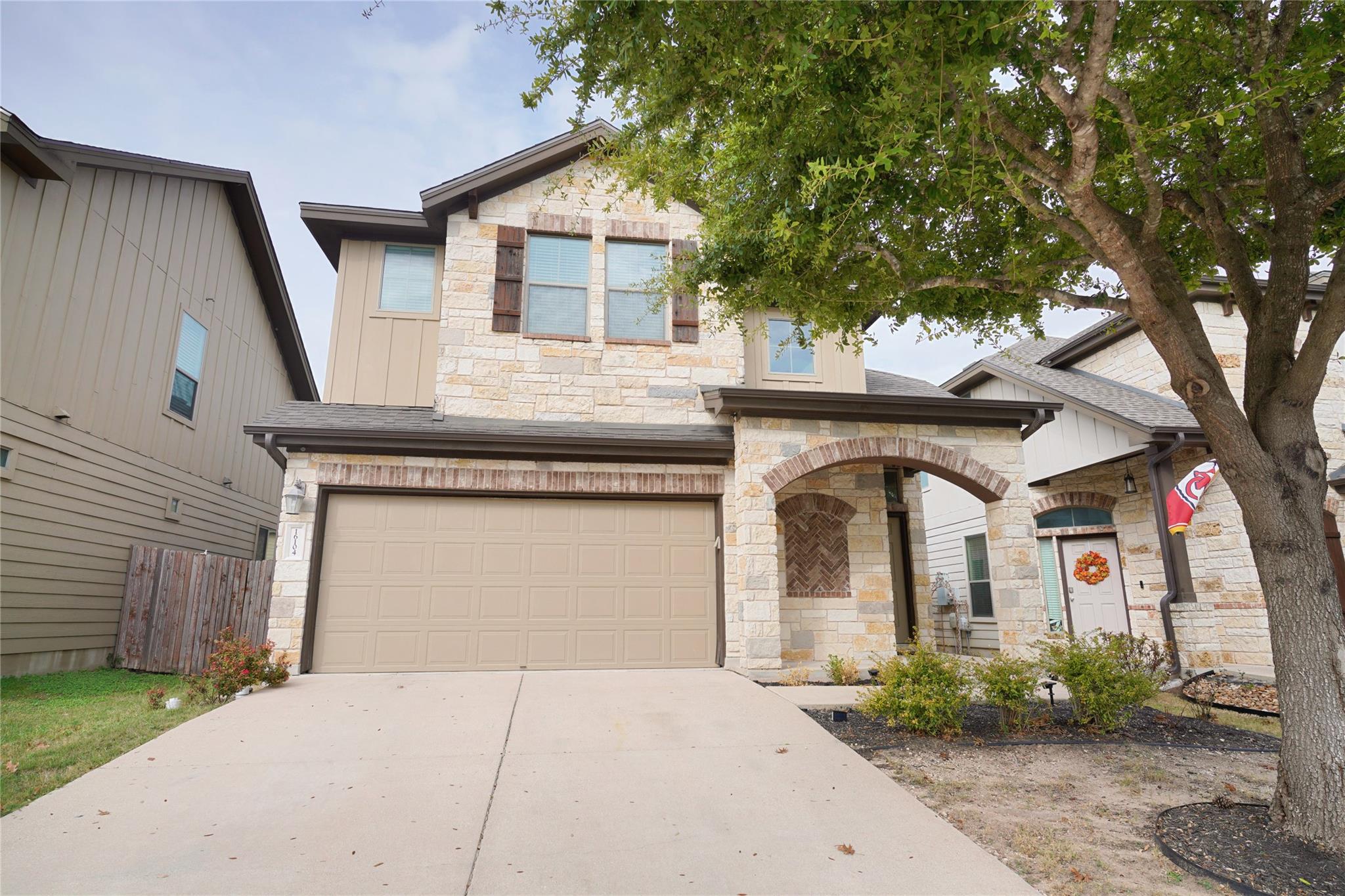 Textured stone veneer, a concrete driveway, and a
