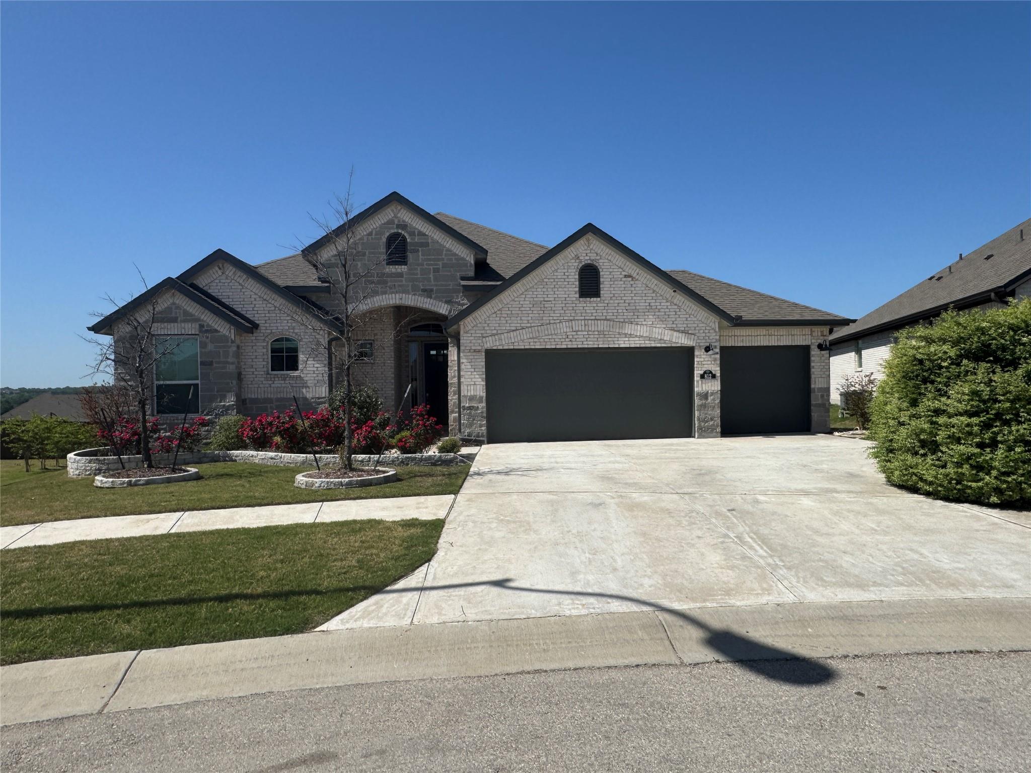 French country style house with stone siding, a g
