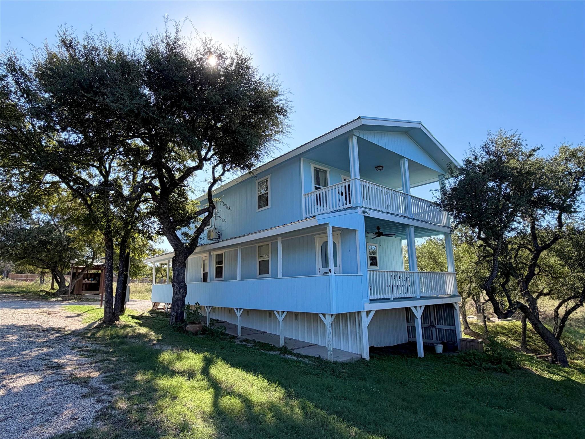 Mature shade trees flank this elevated coastal-st