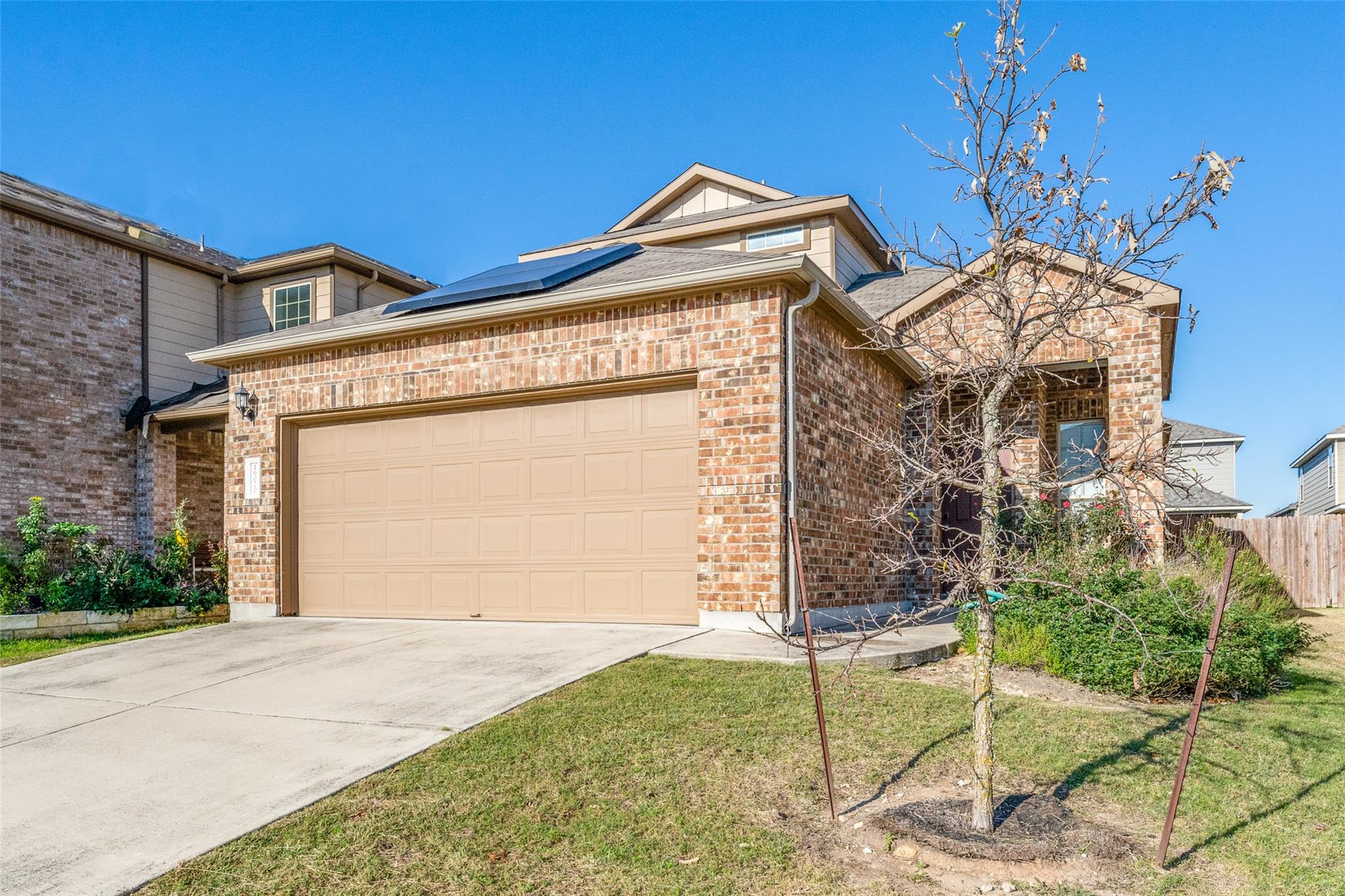 Brick detailing and a concrete driveway complemen