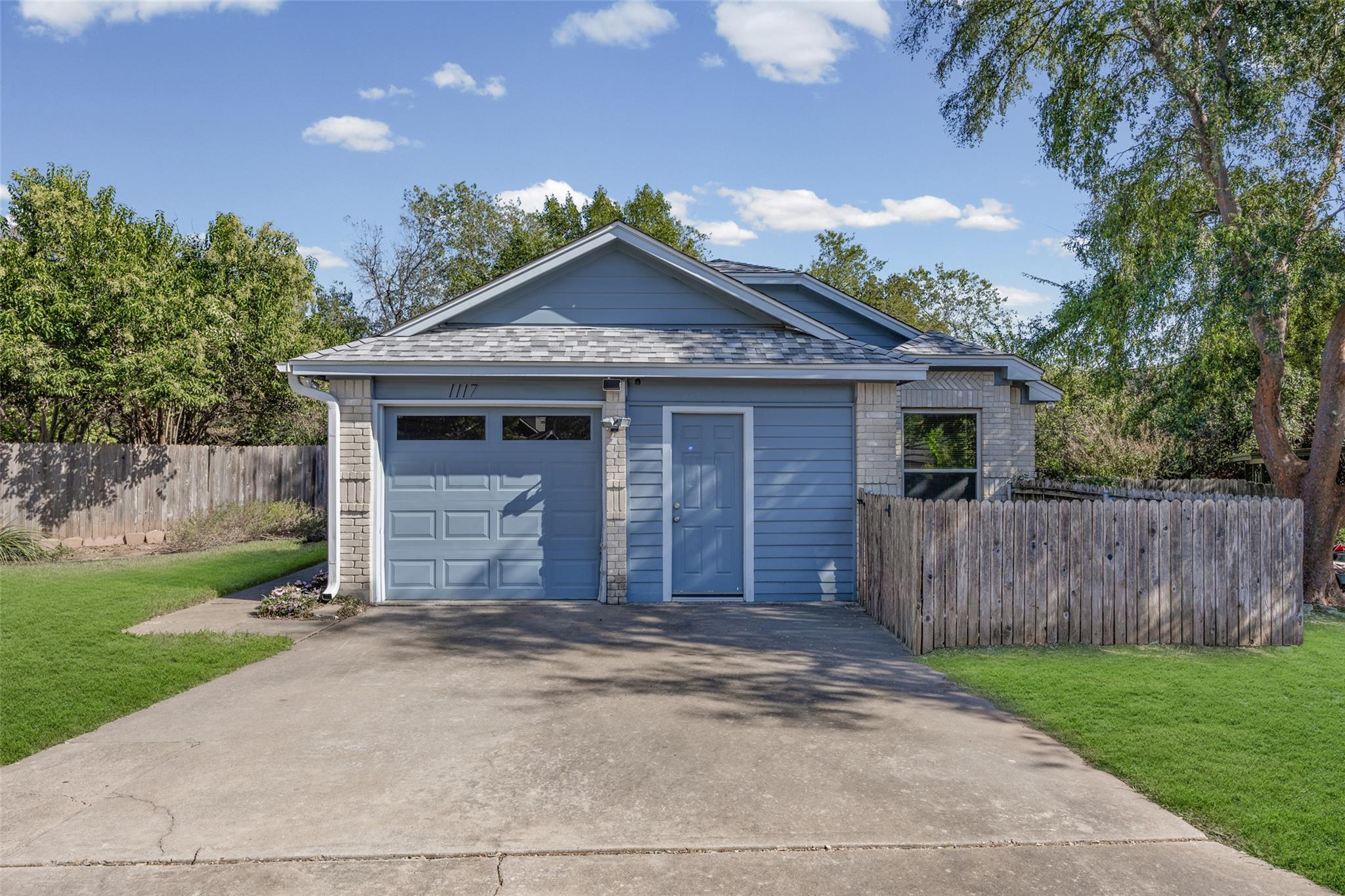A classic concrete driveway leads to an attached 