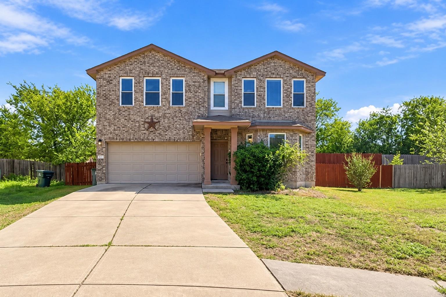 A spacious concrete driveway leads to a two-story