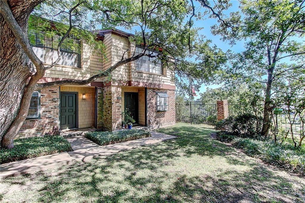 Mature shade trees frame the brick and shingle ex