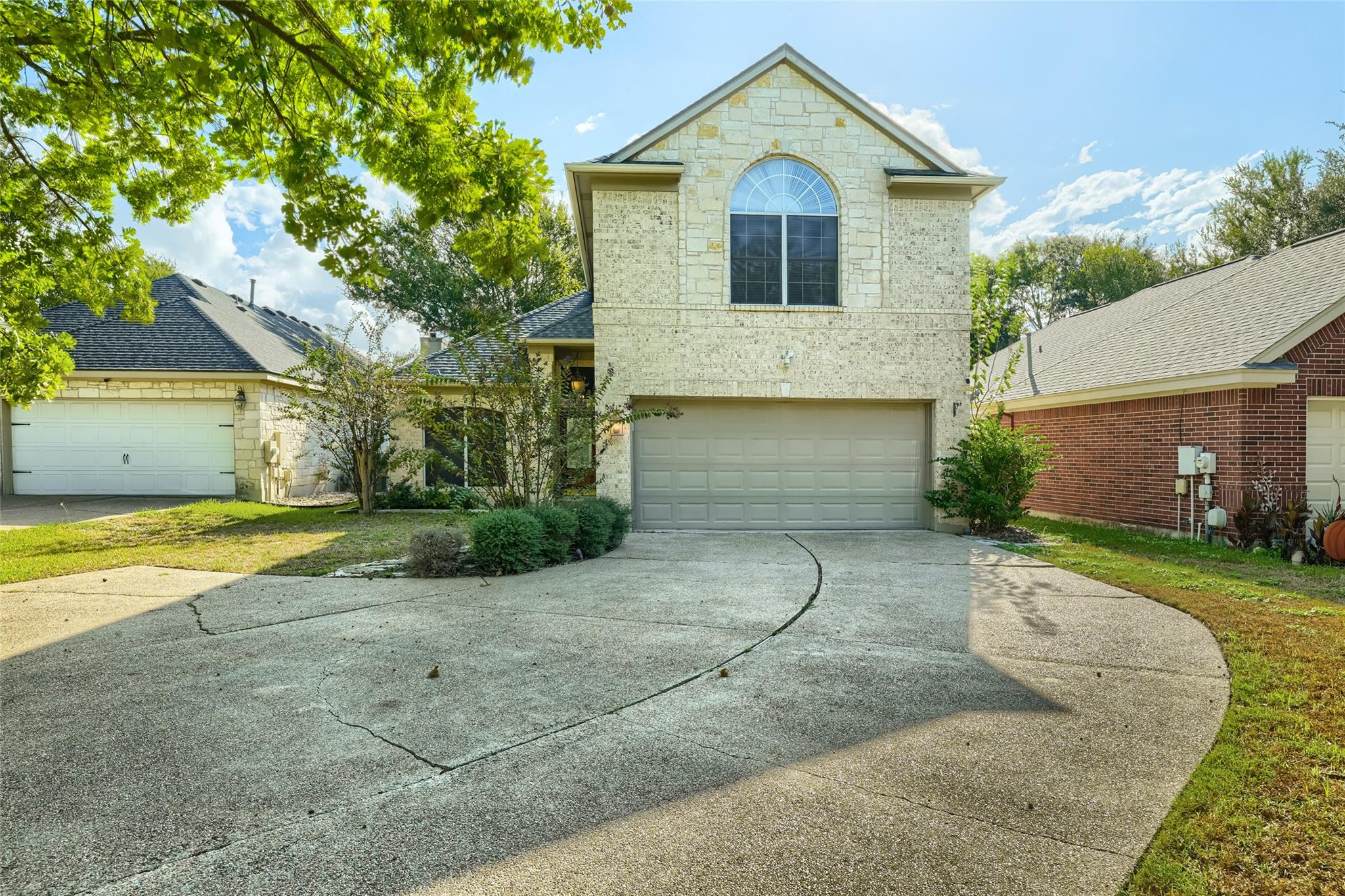 An arched accent window highlights the stone exte
