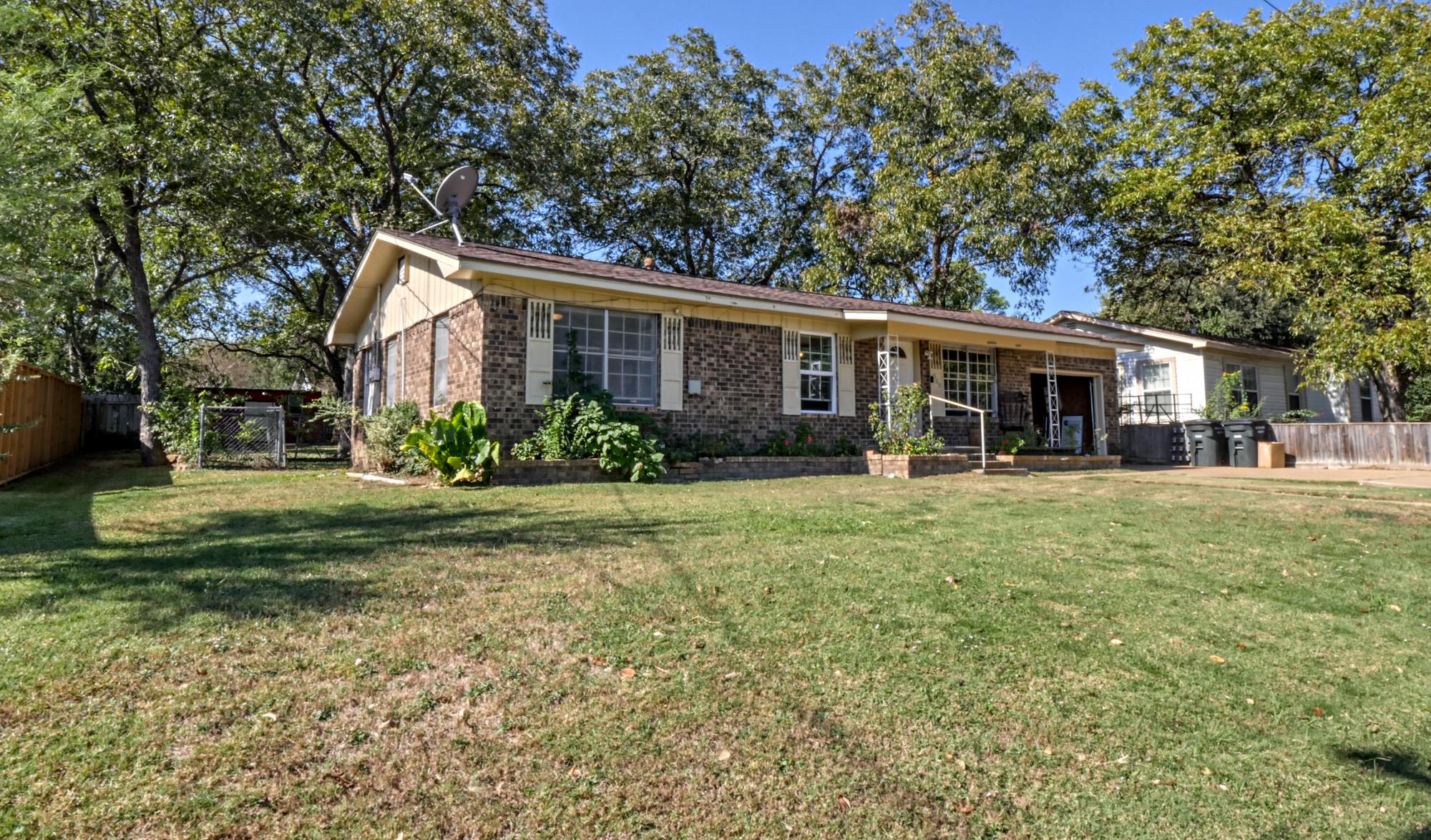 Mature trees shade a classic brick ranch home set
