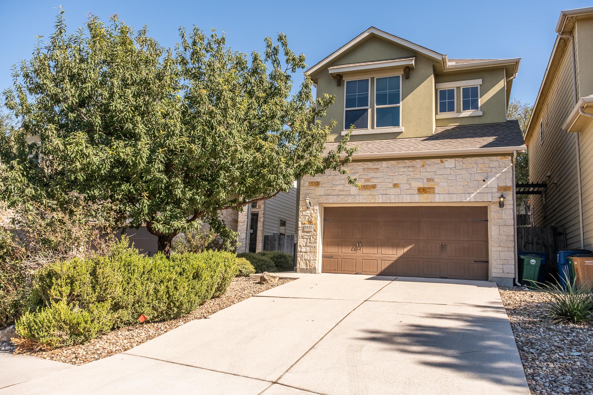 An inviting stone and stucco exterior sits behind