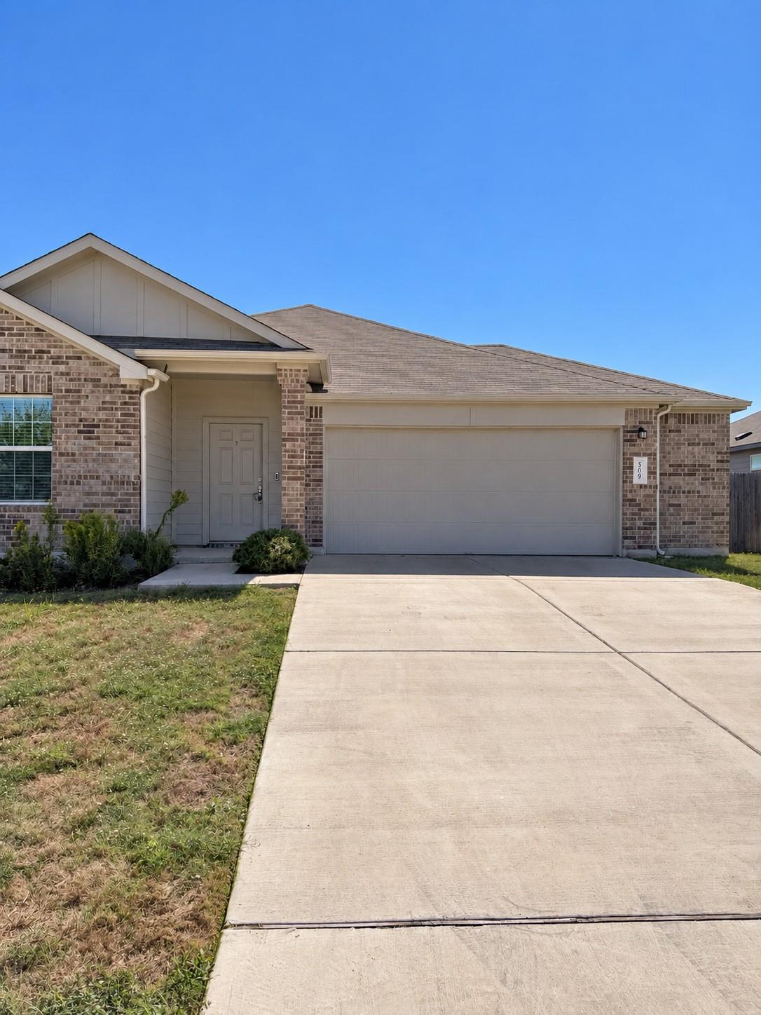 A classic brick exterior and a concrete driveway 