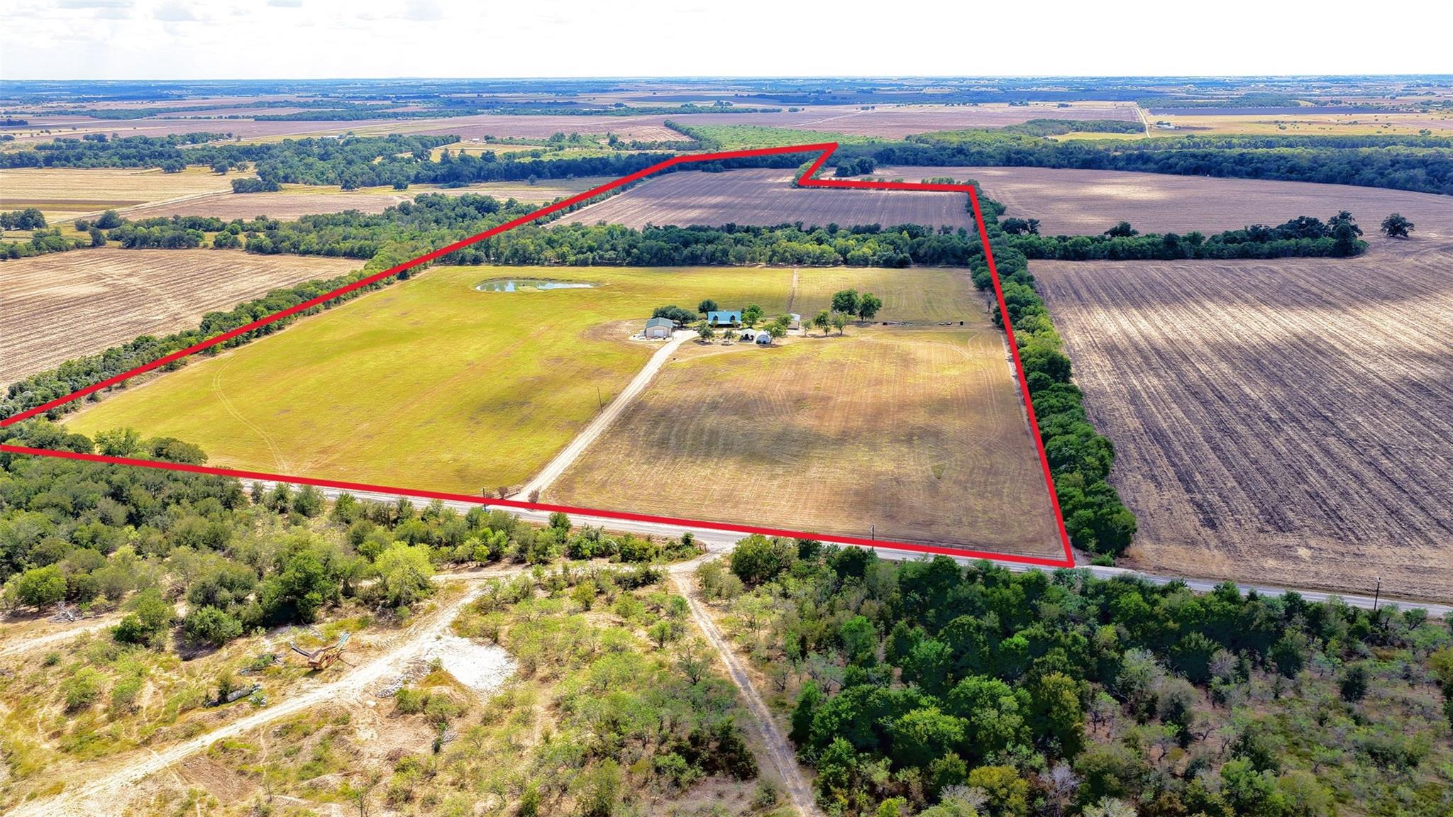 An expansive rural acreage features cleared pastu