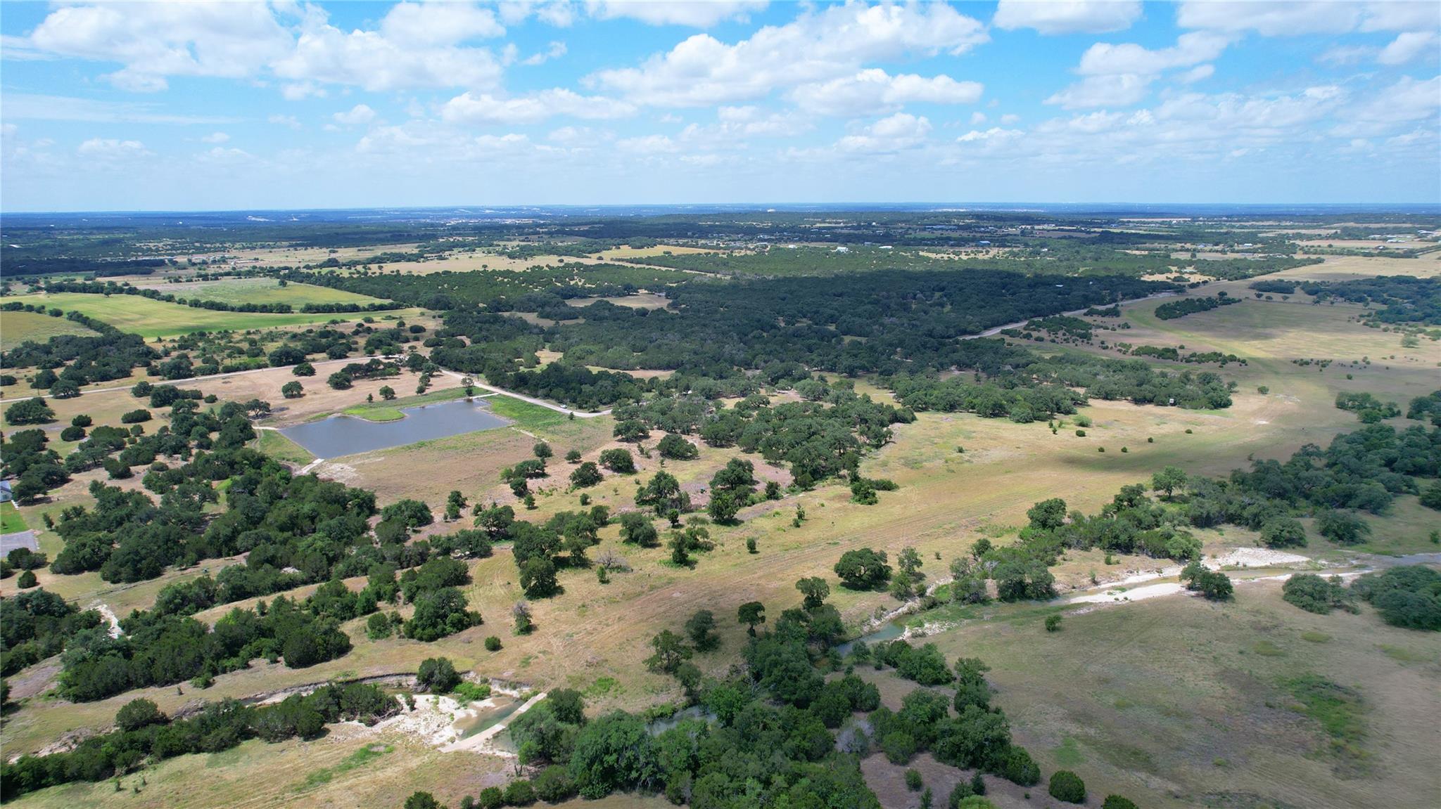 Rolling green pastures and mature trees stretch a
