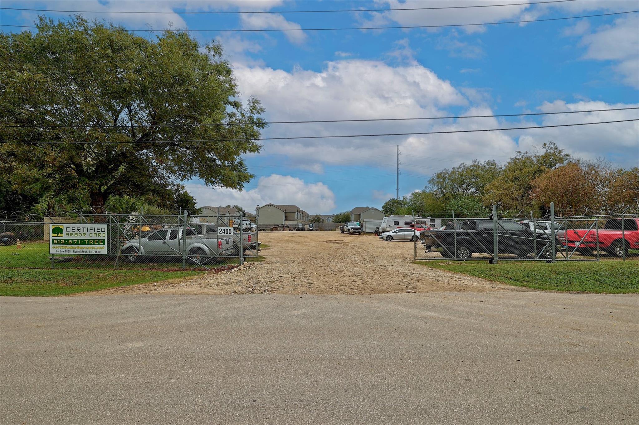 A secure gated entry opens to a spacious dirt lot