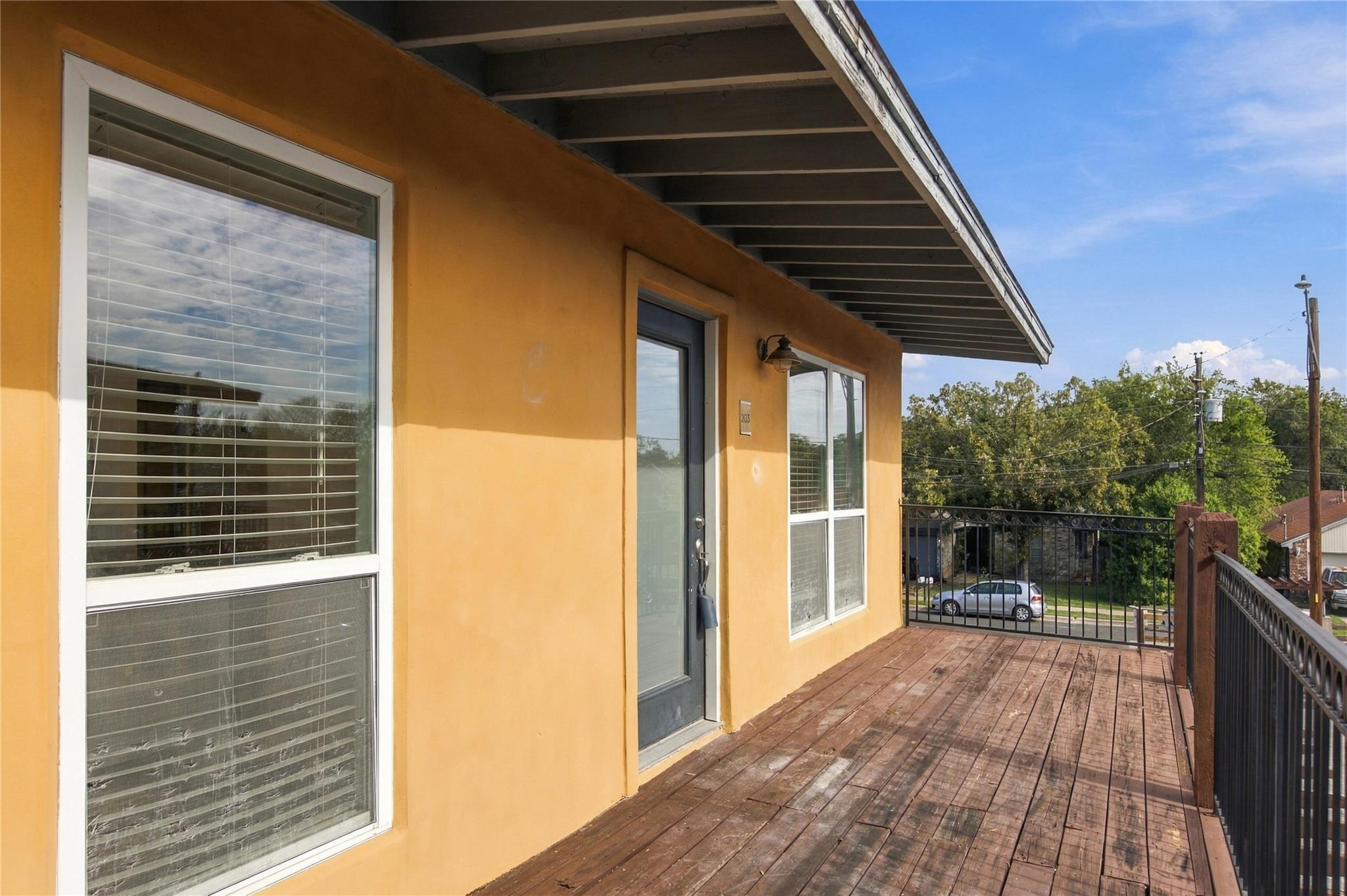 An elevated wood-plank deck features metal railin
