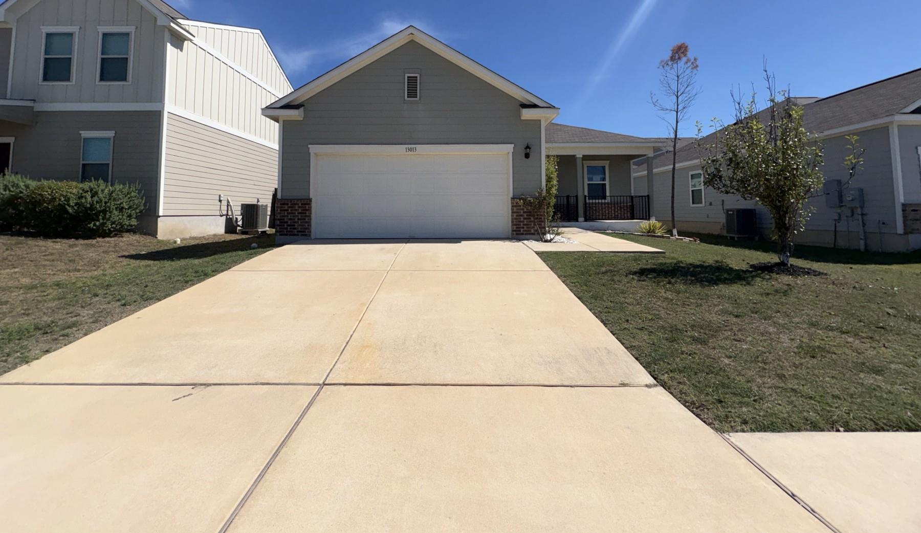 A wide concrete driveway leads to the front-loadi