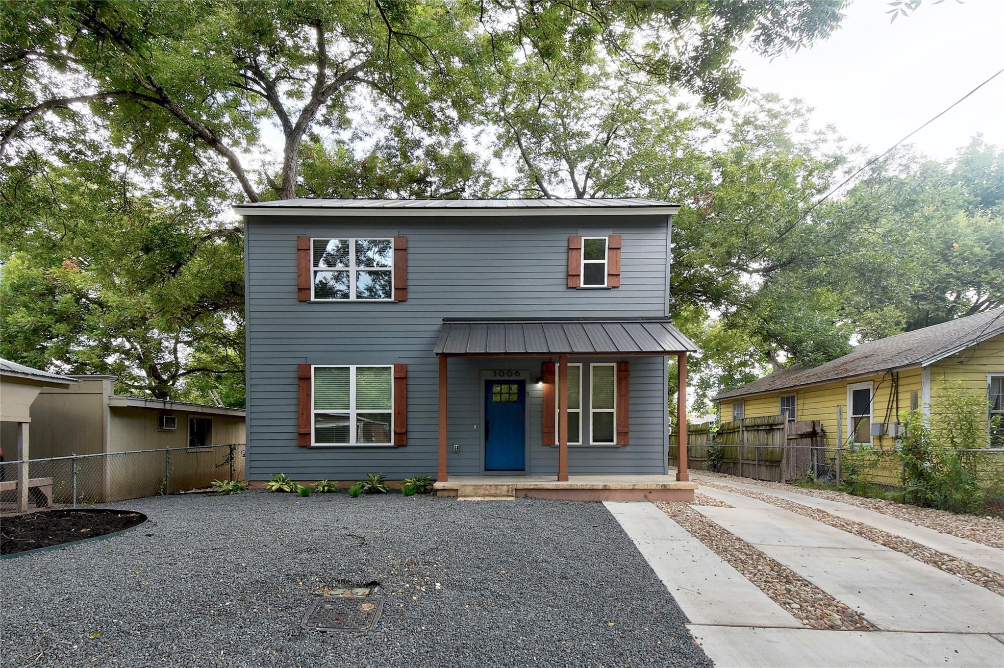 Mature trees frame this two-story home featuring 