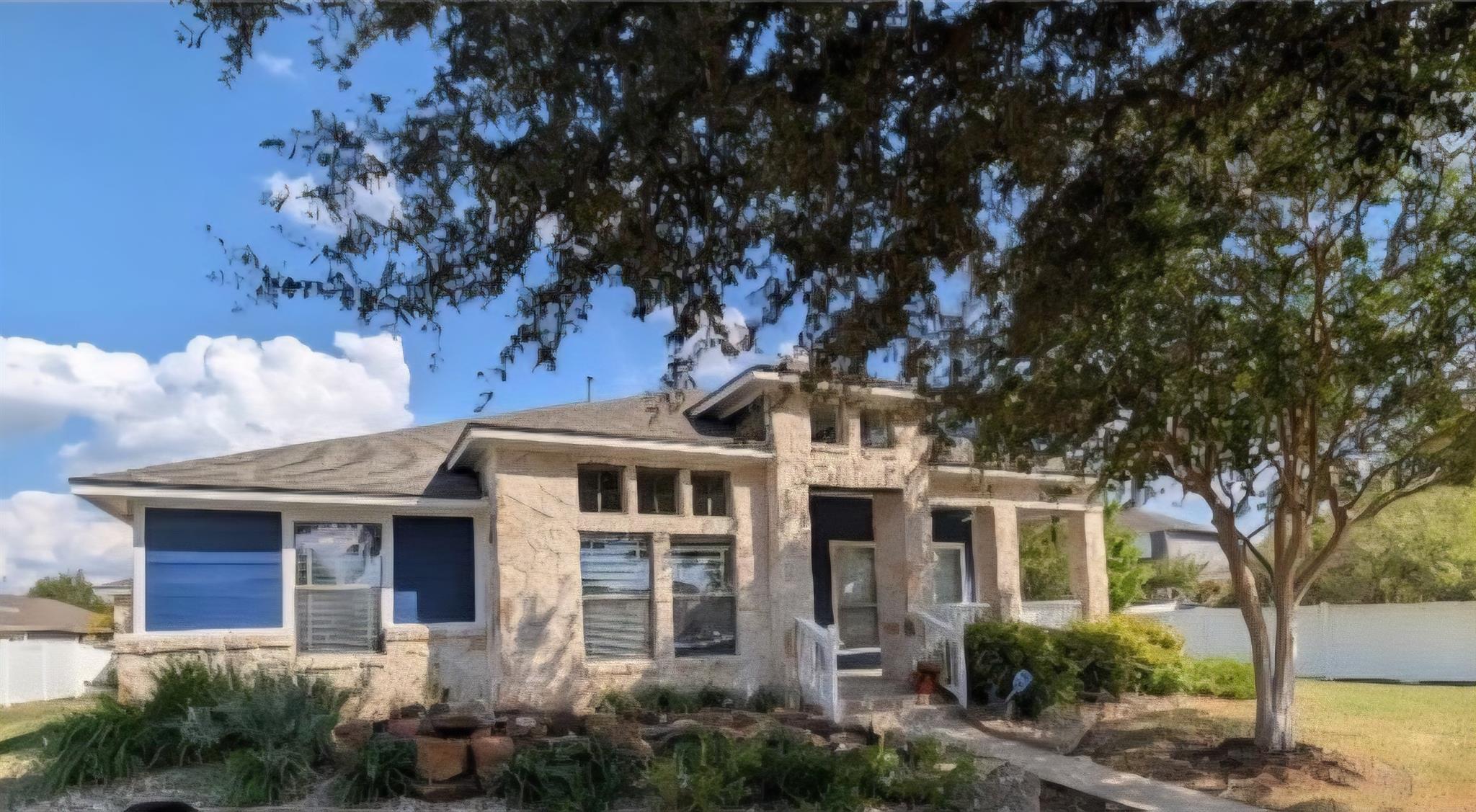 A classic stone facade and mature trees create an