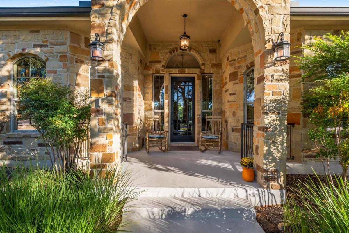 A welcoming stone archway frames the front entry 