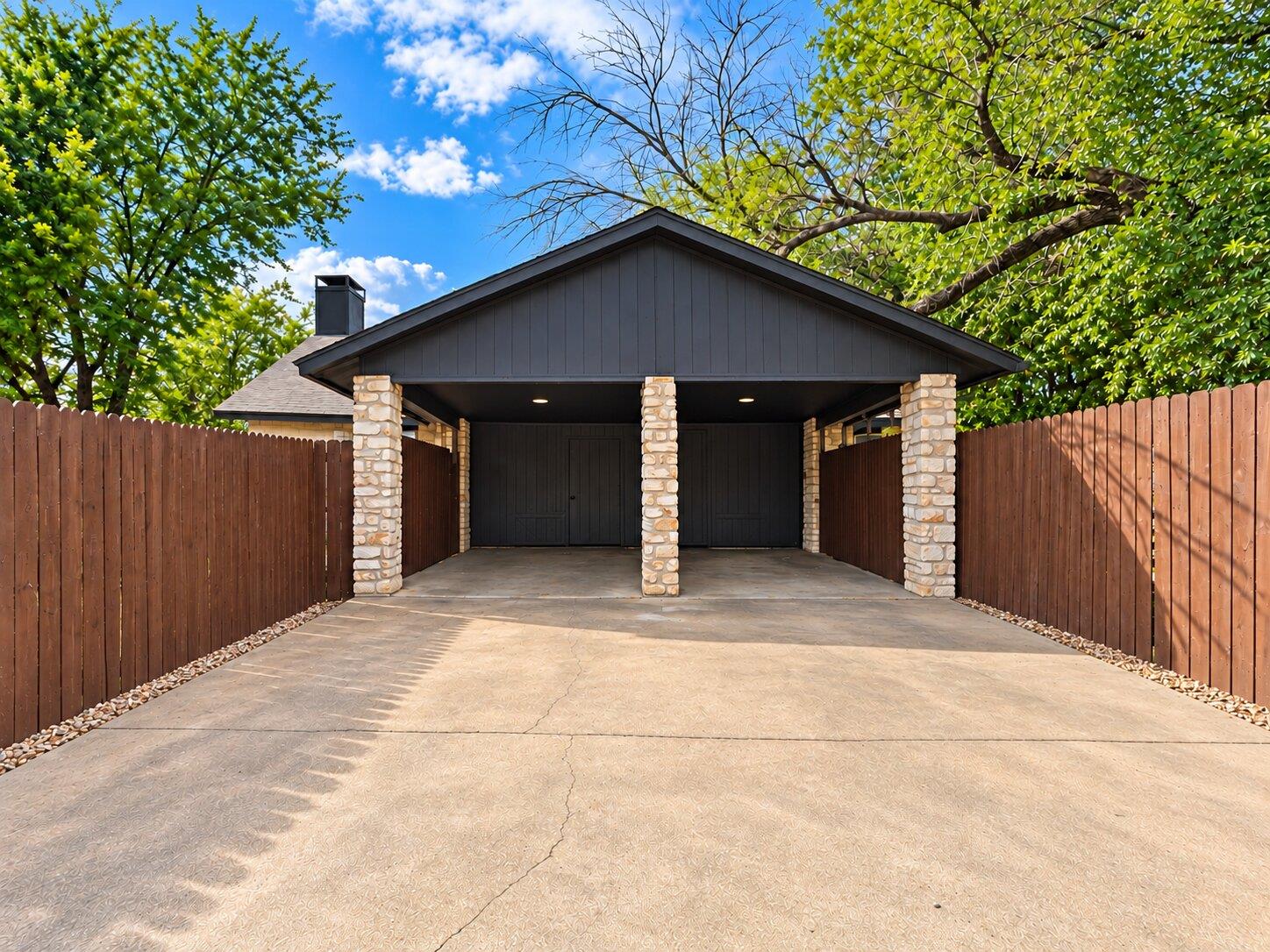 Stone pillars support a covered carport set at th