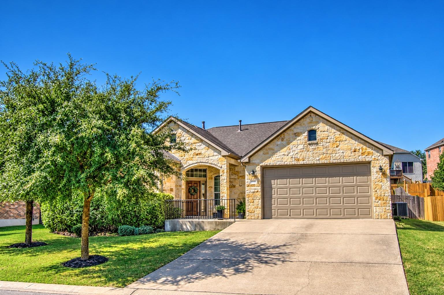 A classic stone exterior and a manicured lawn def