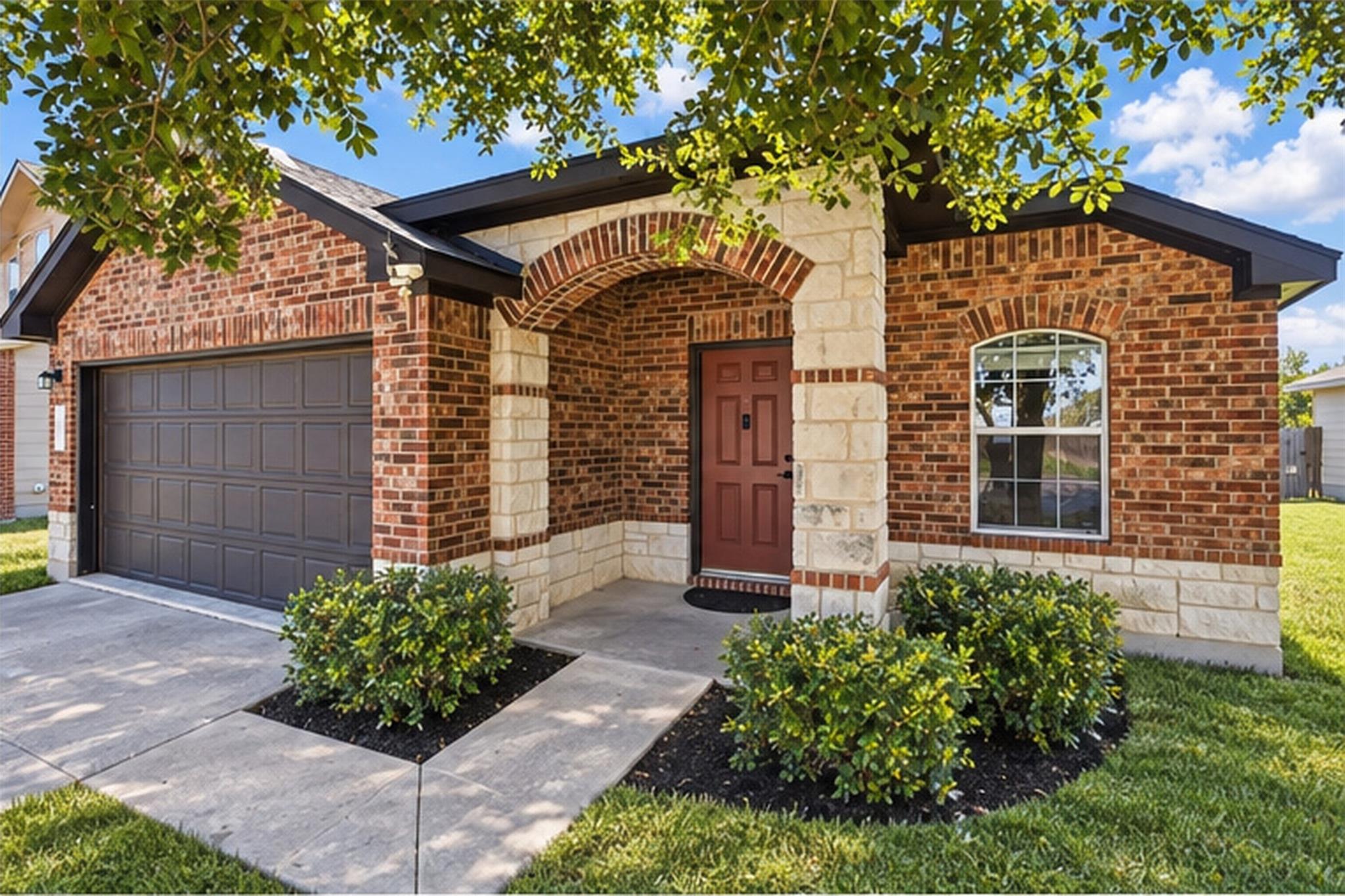 An inviting stone and brick entryway leads to a c