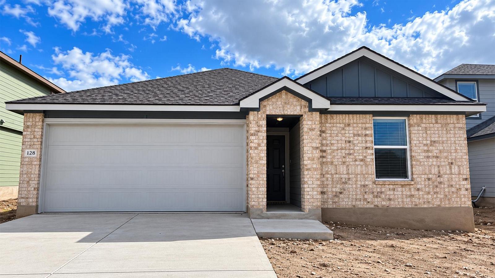 Brick accents and a clean concrete driveway creat