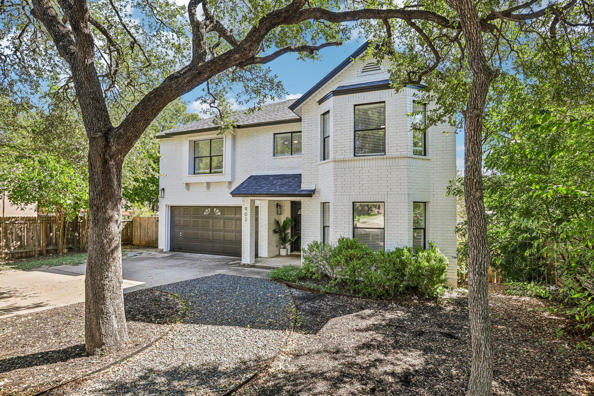 Mature trees frame a classic brick exterior with 