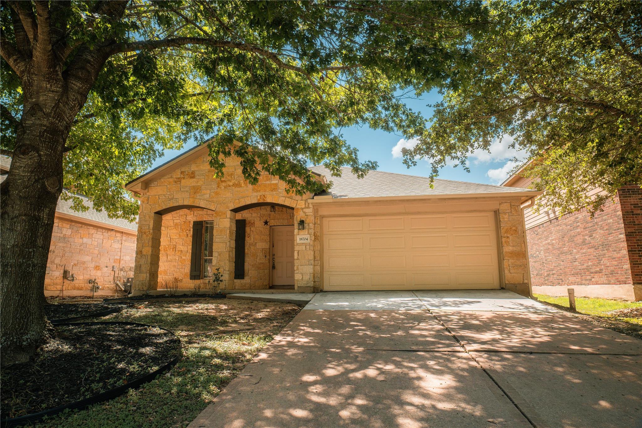Mature trees shade a classic stone exterior with 