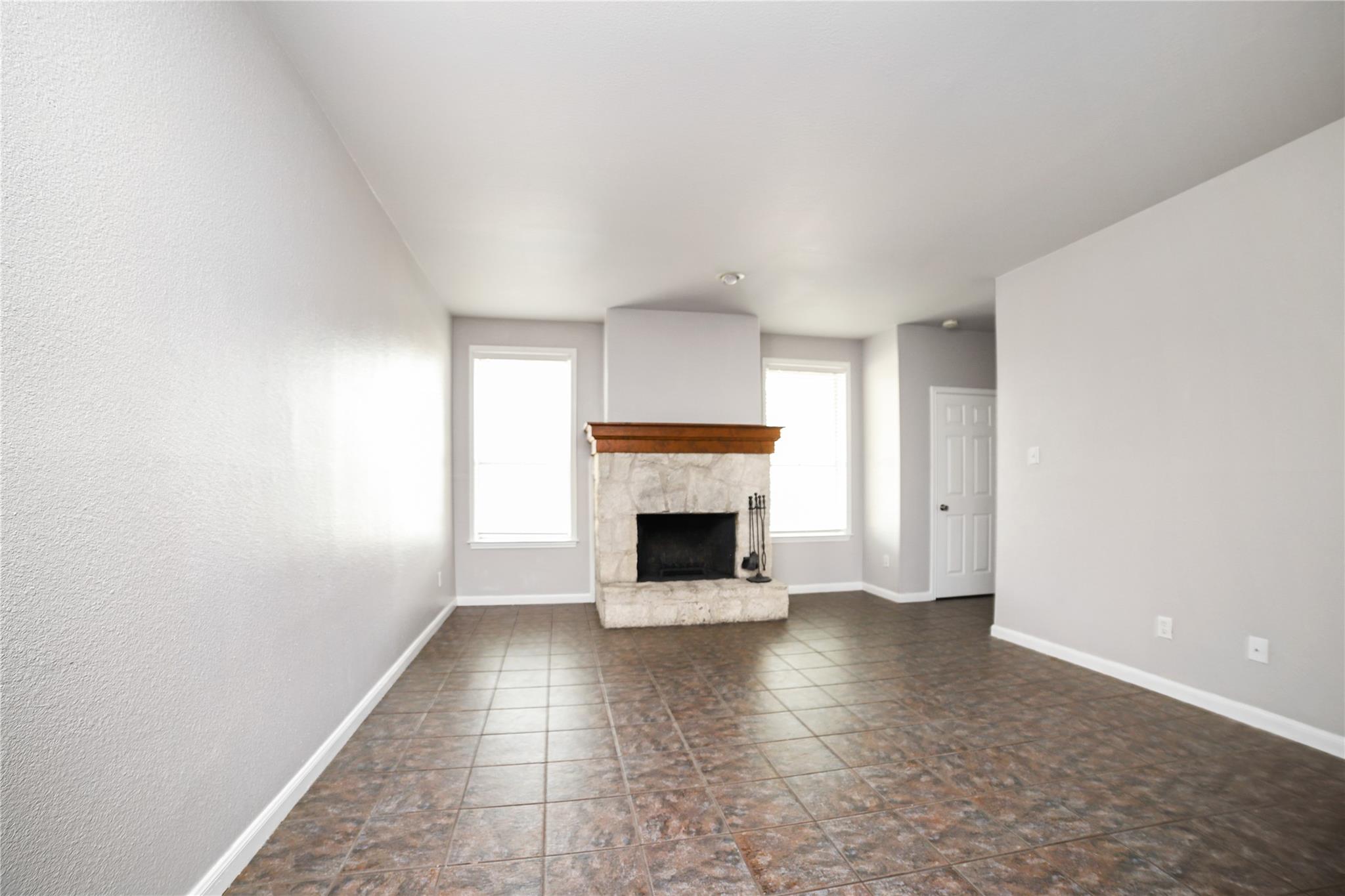 Tiled flooring and a stone fireplace define this 