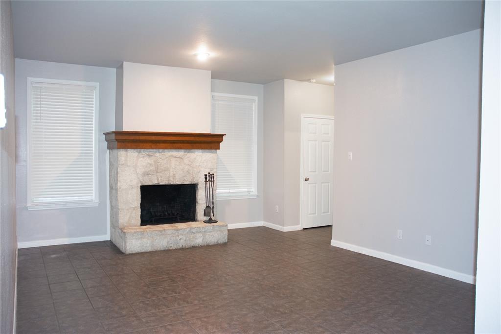 An inviting stone fireplace anchors this living s