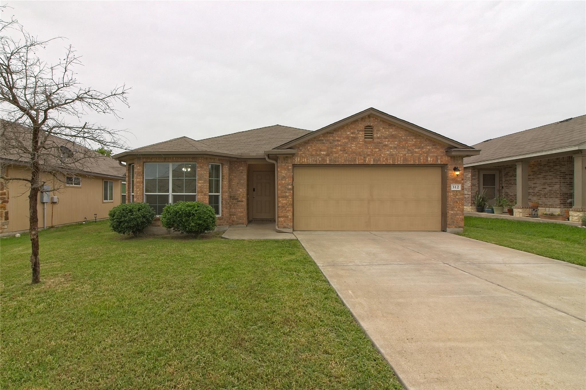 A classic brick exterior and concrete driveway de