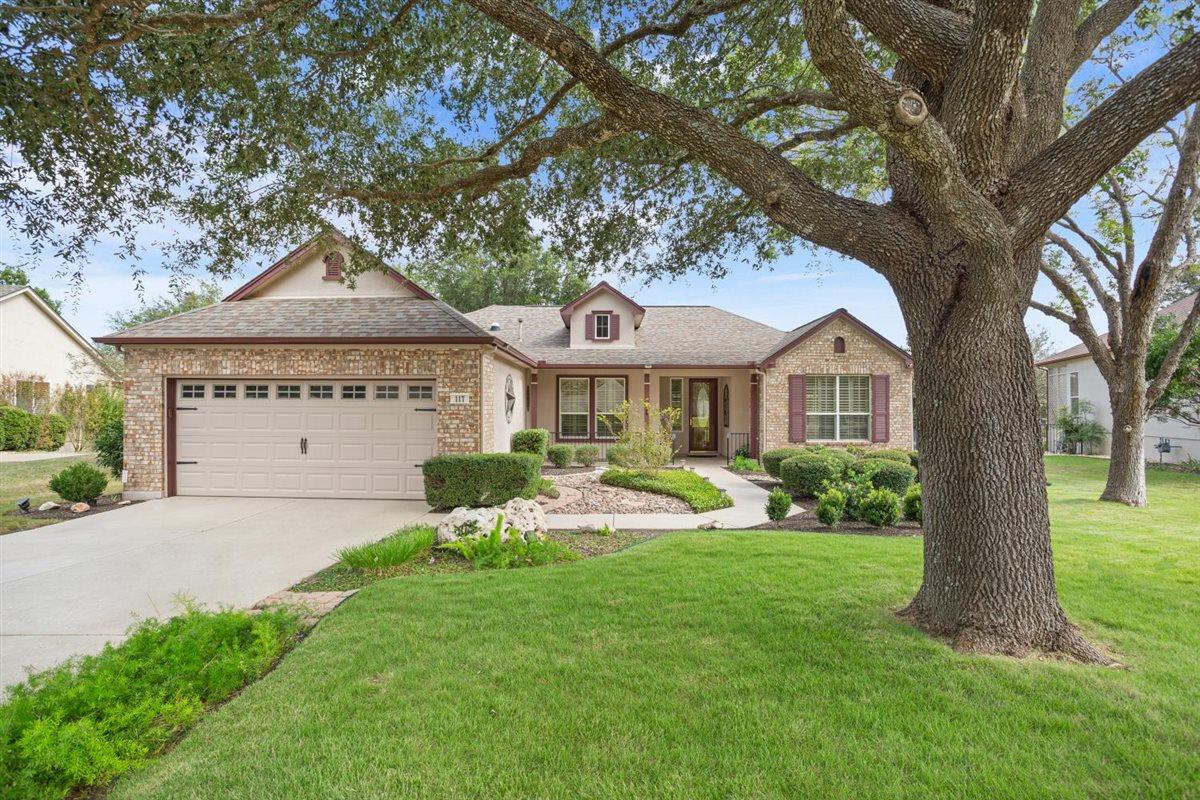 Mature oak trees shade the manicured lawn of this