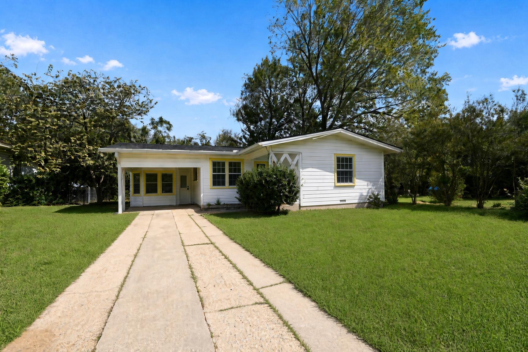 An inviting paved driveway leads to this classic 