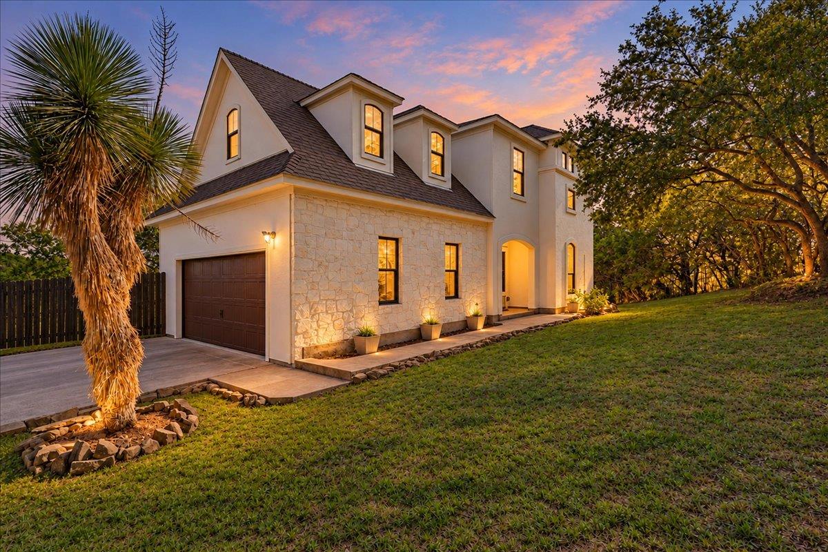 Warm exterior lighting accents the stone veneer f