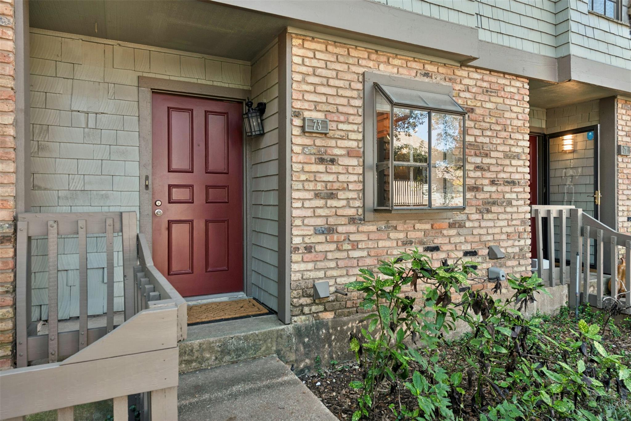 Exposed brick accents and shake siding frame the 