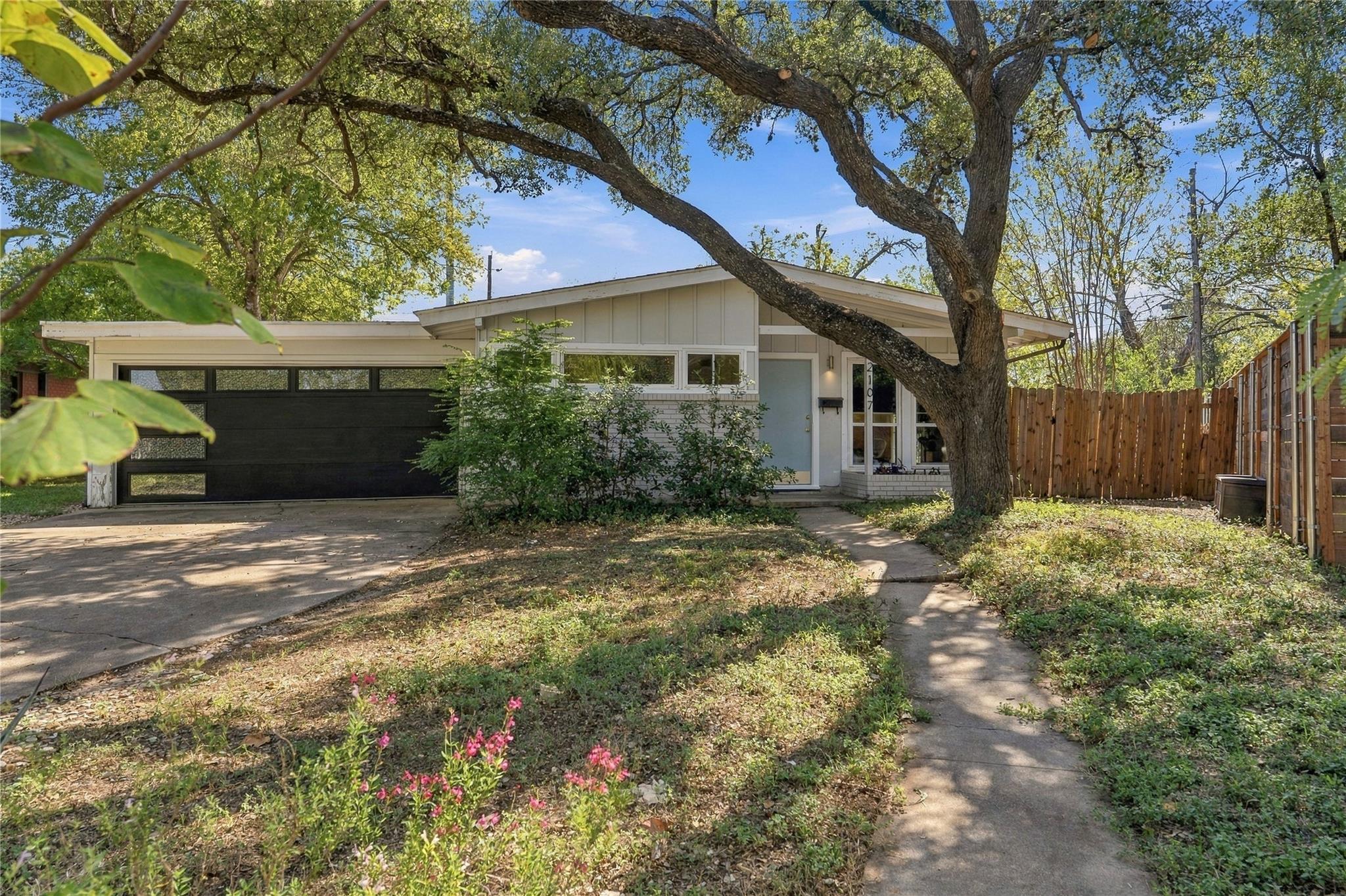 Mature shade trees frame this classic mid-century