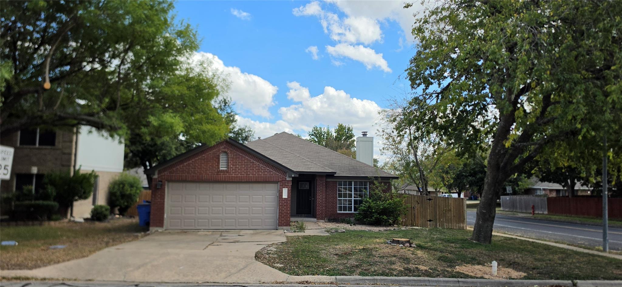 Mature trees frame a classic brick exterior featu