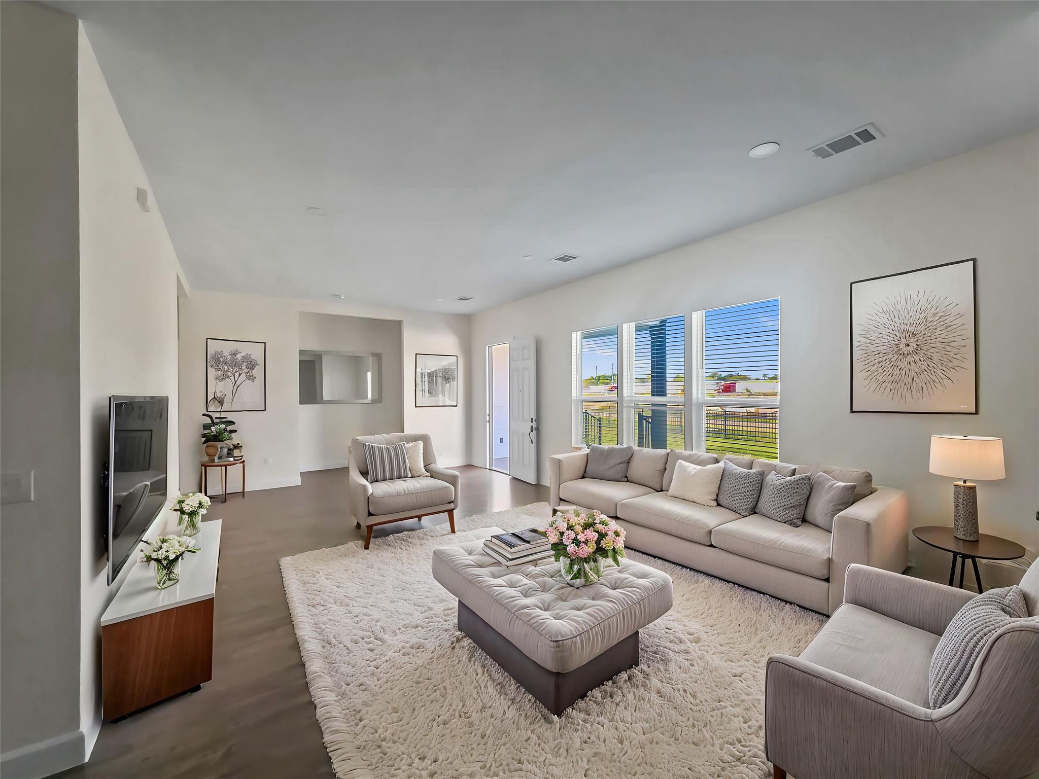 An open living space features recessed lighting, 