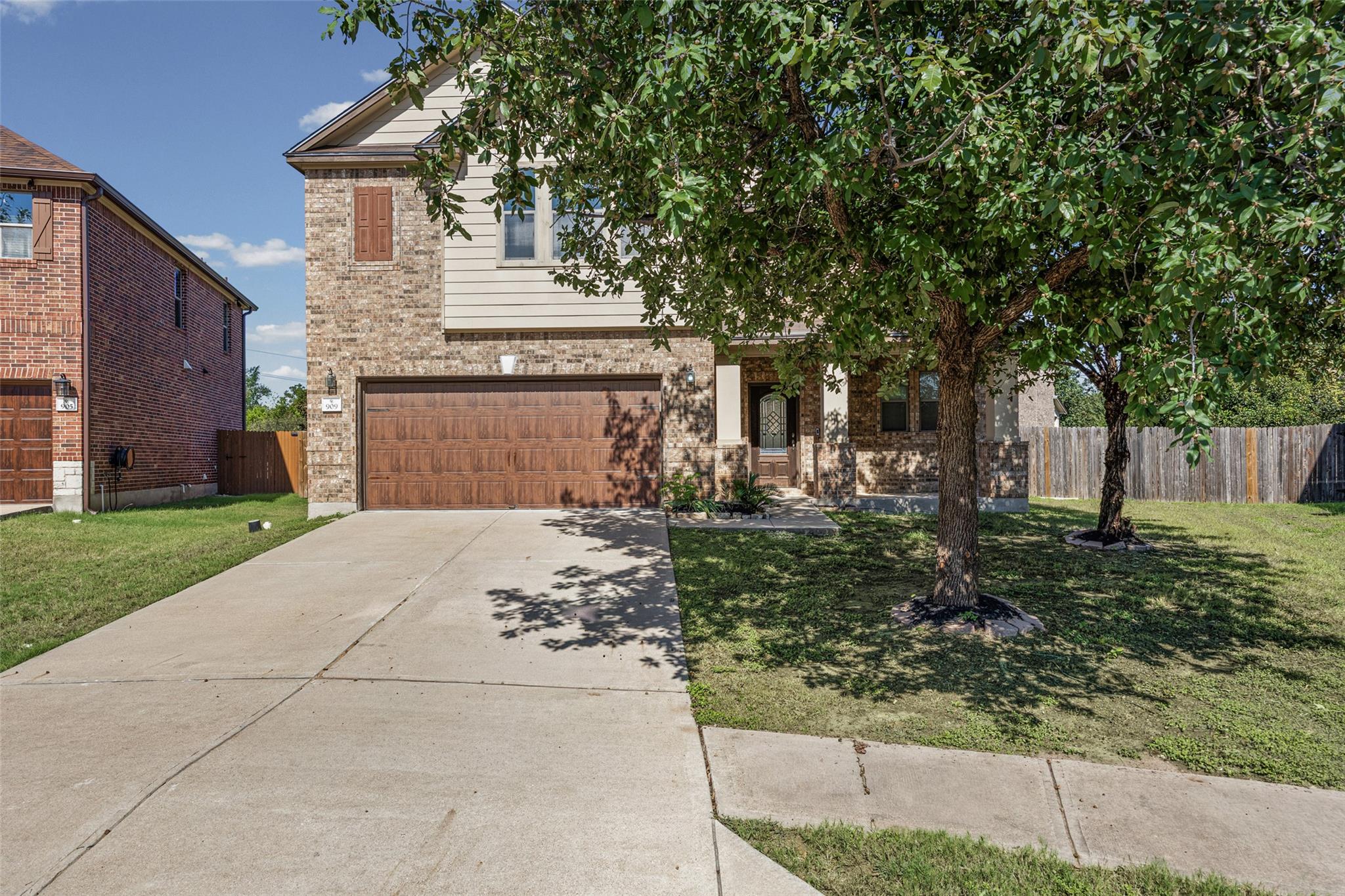 Mature trees shade the front lawn of this two-sto