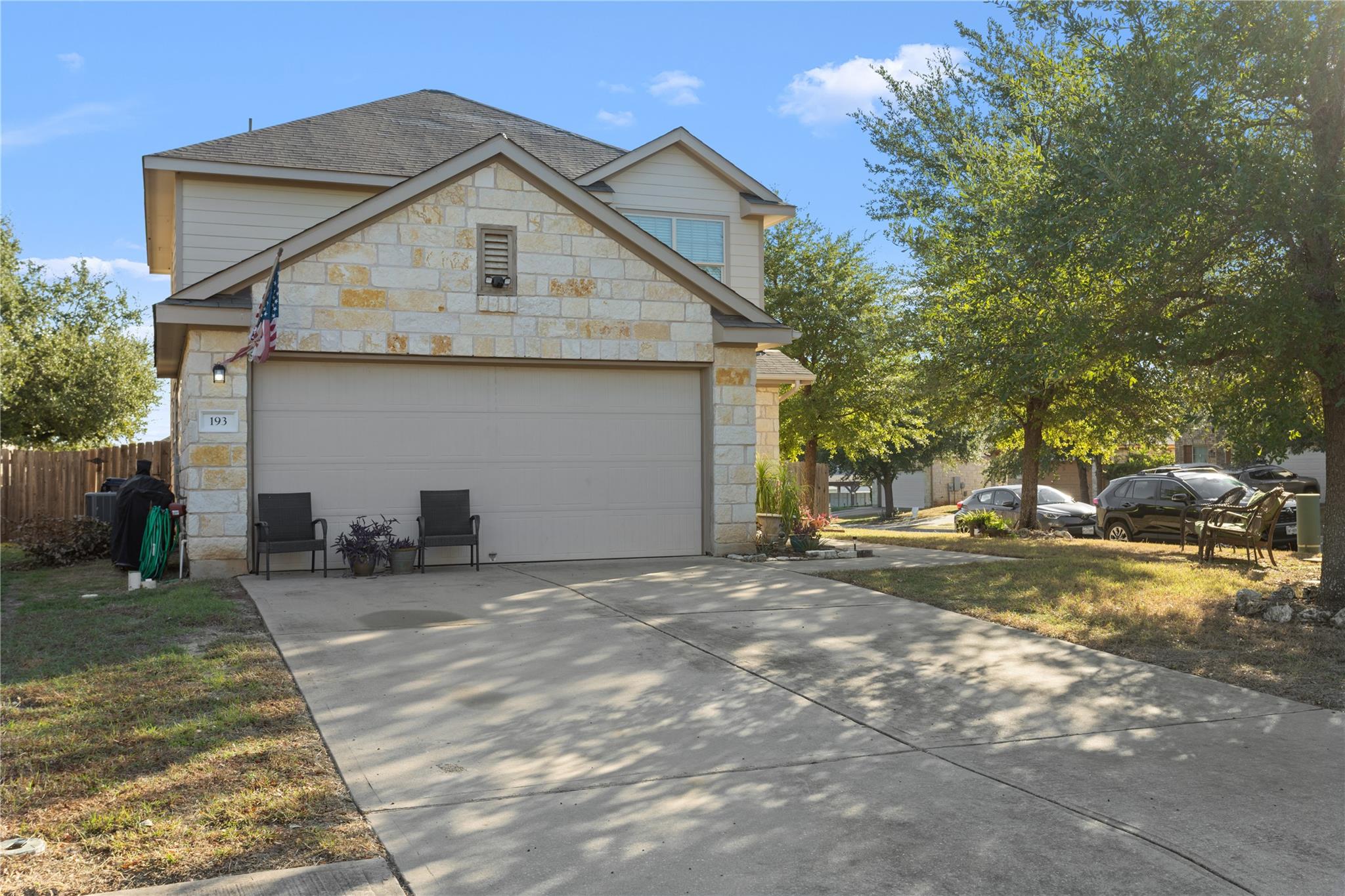 Limestone masonry and a wide concrete driveway hi