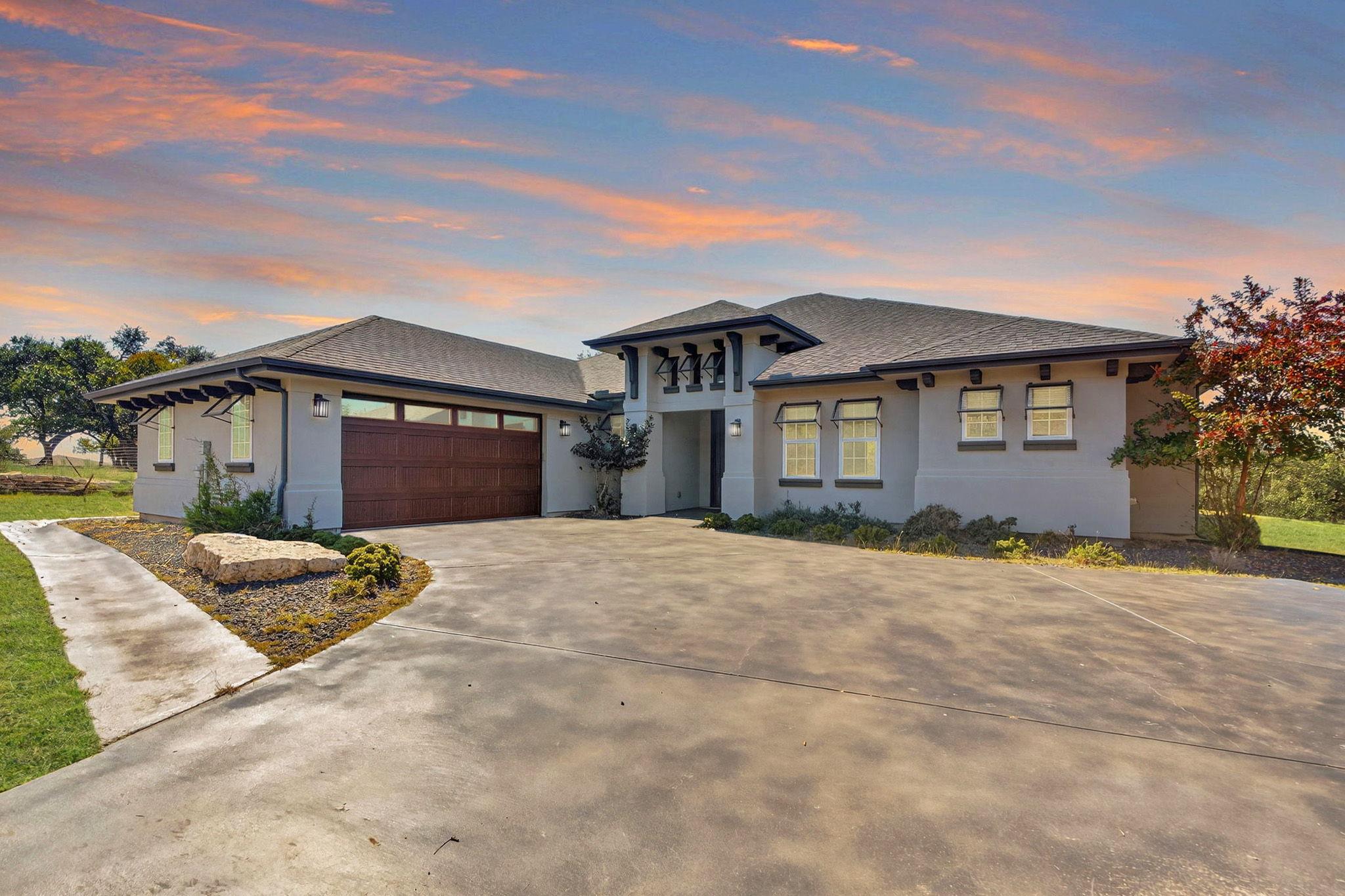 An expansive concrete driveway leads directly to 