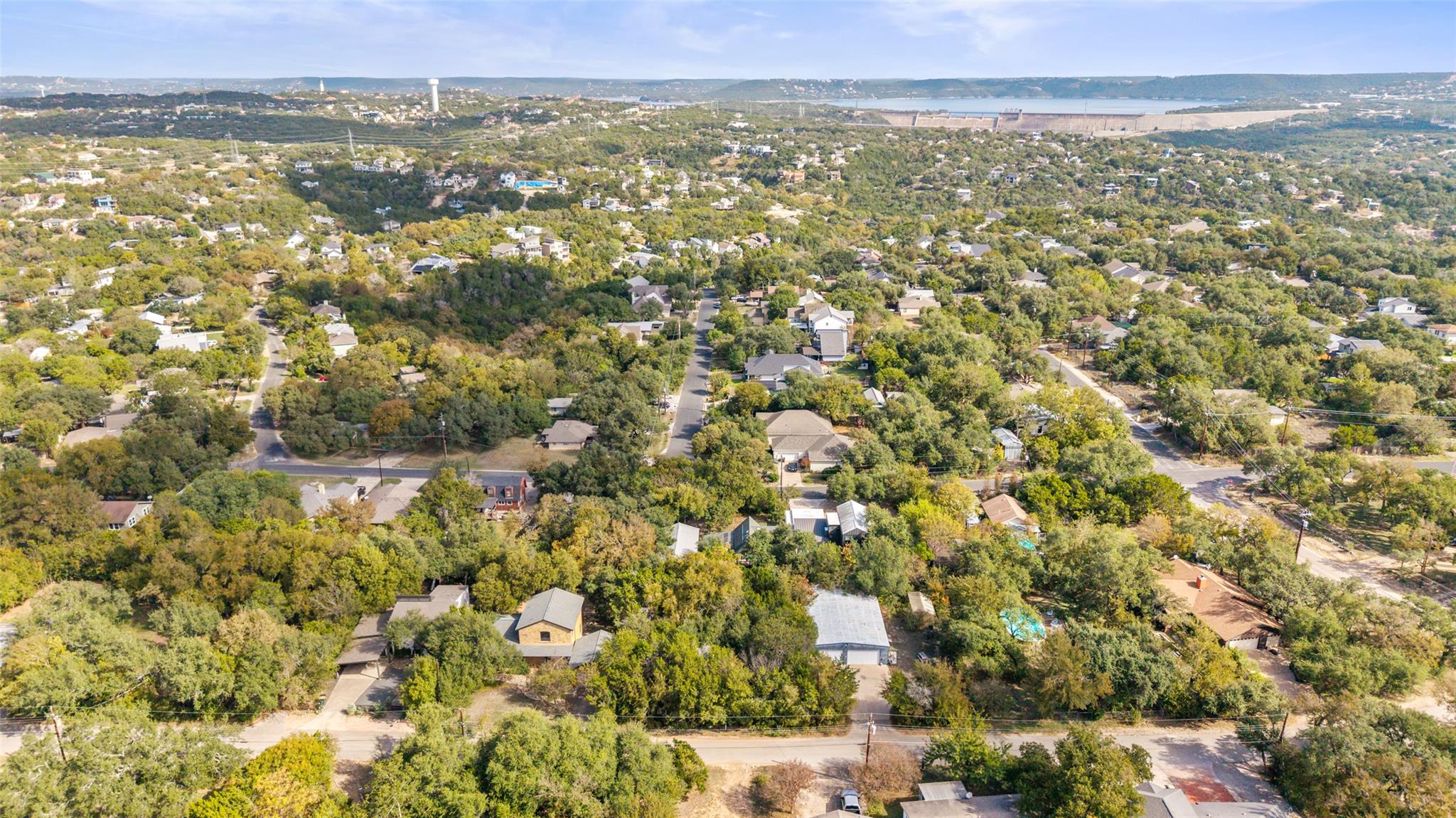Lush green trees surround homes in a peaceful nei
