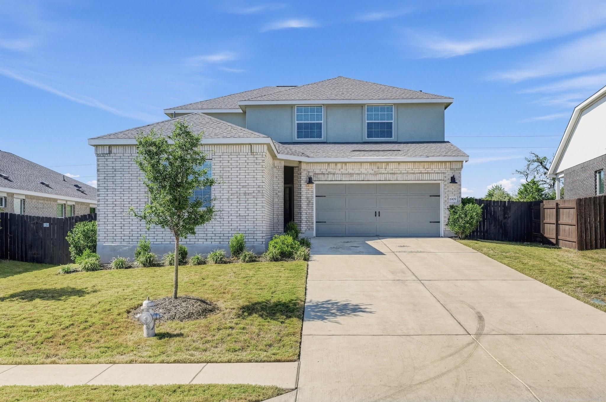 A concrete driveway leads to the front-loading ga